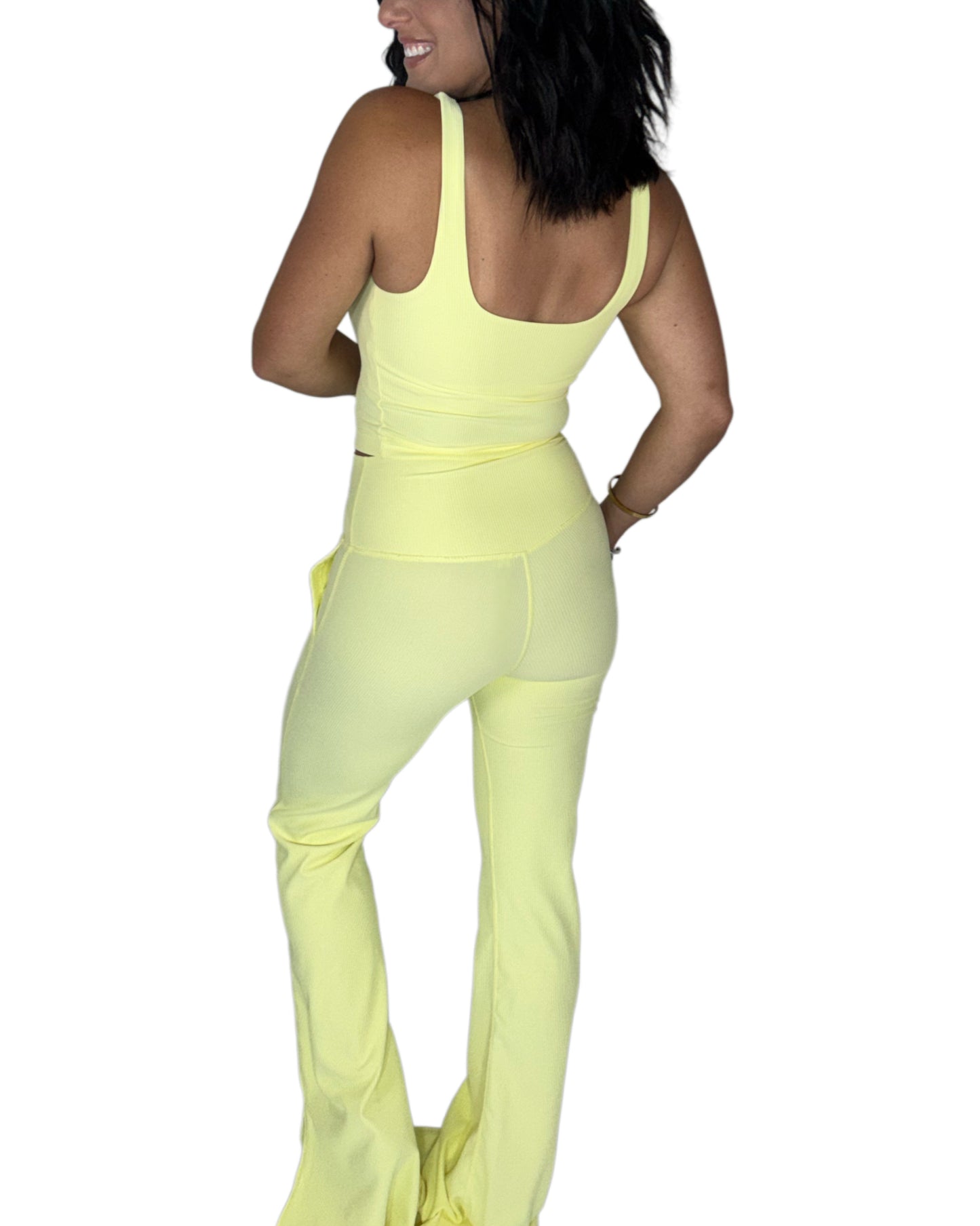 Back profile of a woman wearing a ribbed active pant set on a white background