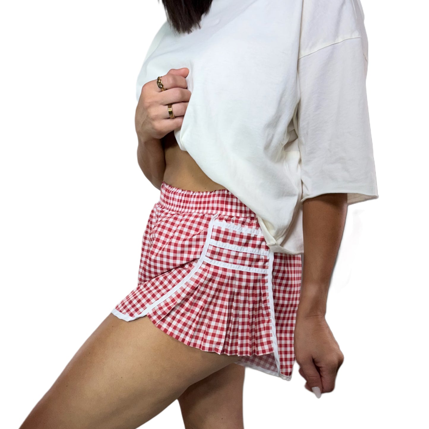 Person wearing a red and white checkered skirt with a plain white background