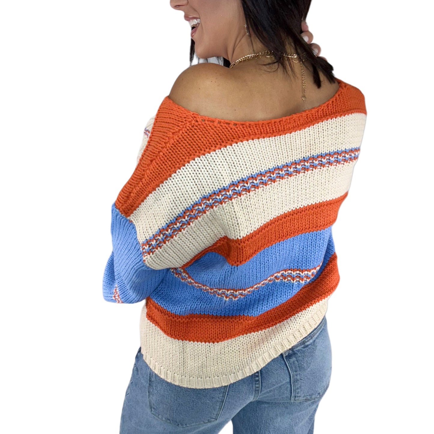 Woman modeling the back of a colorful striped sweater on a white background