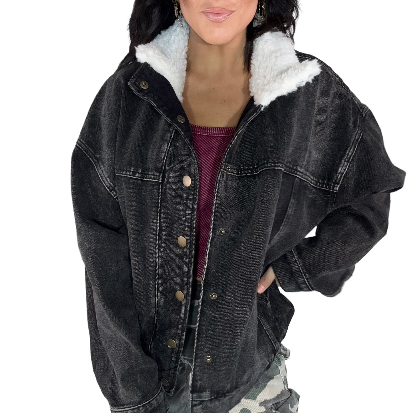 Black denim jacket with white fur lining worn by a woman on a white background