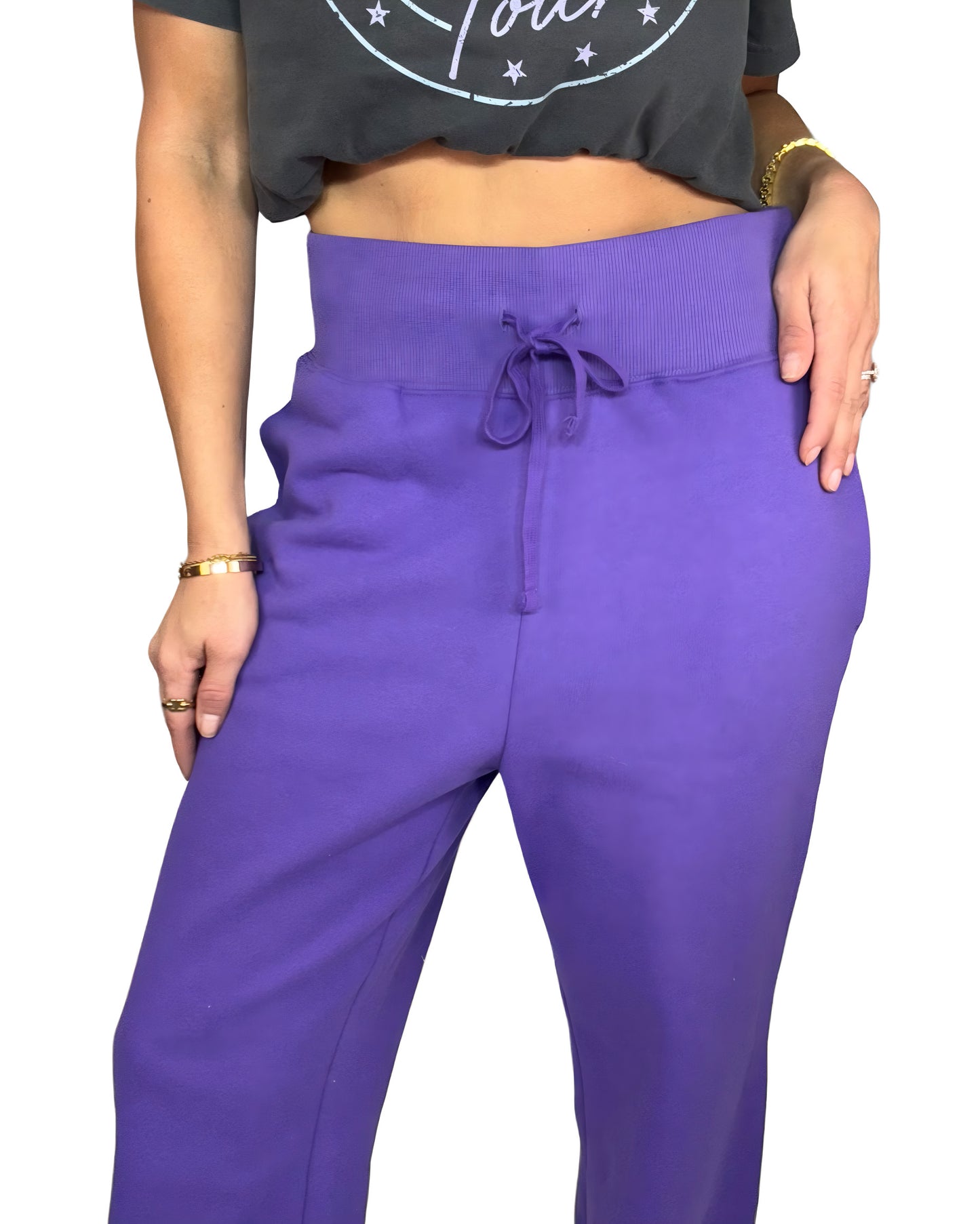 Woman wearing purple joggers with grey tee and white background