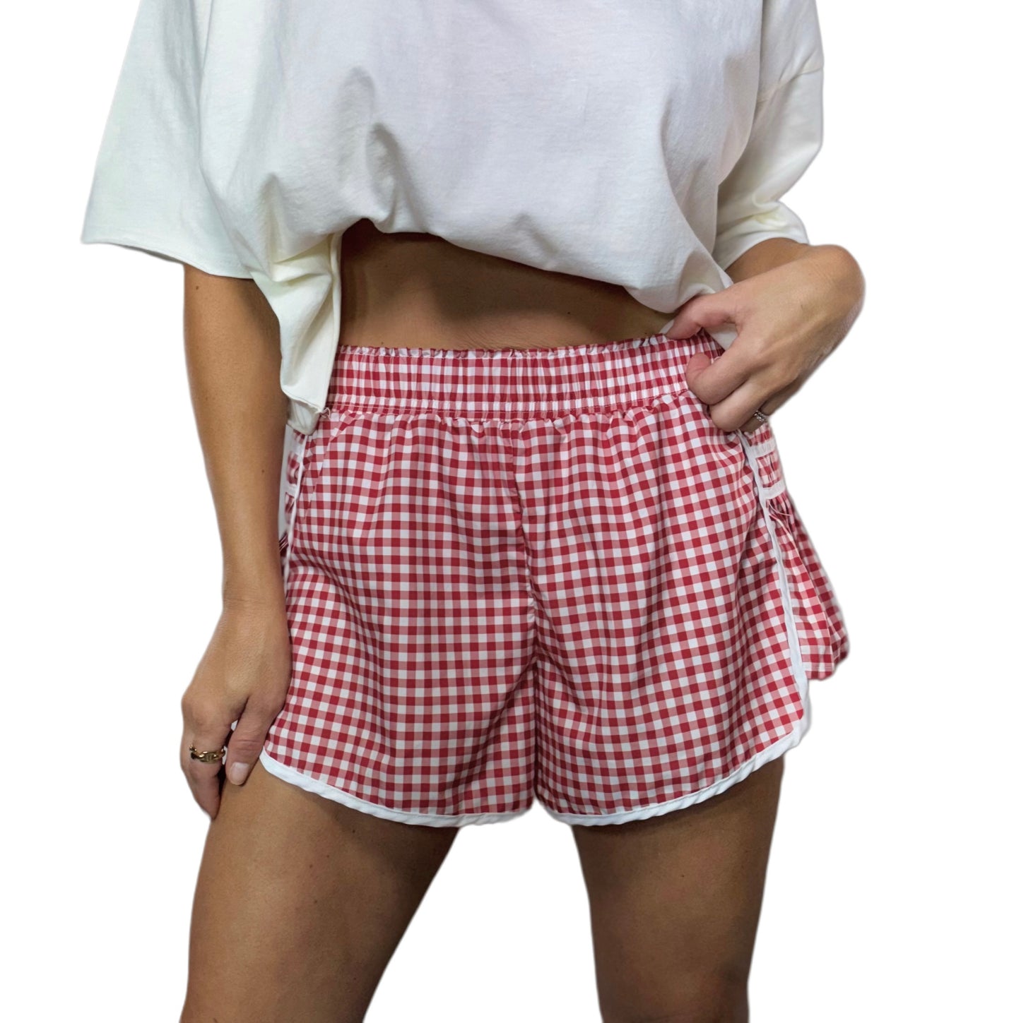 Person wearing red and white checkered shorts on a white background