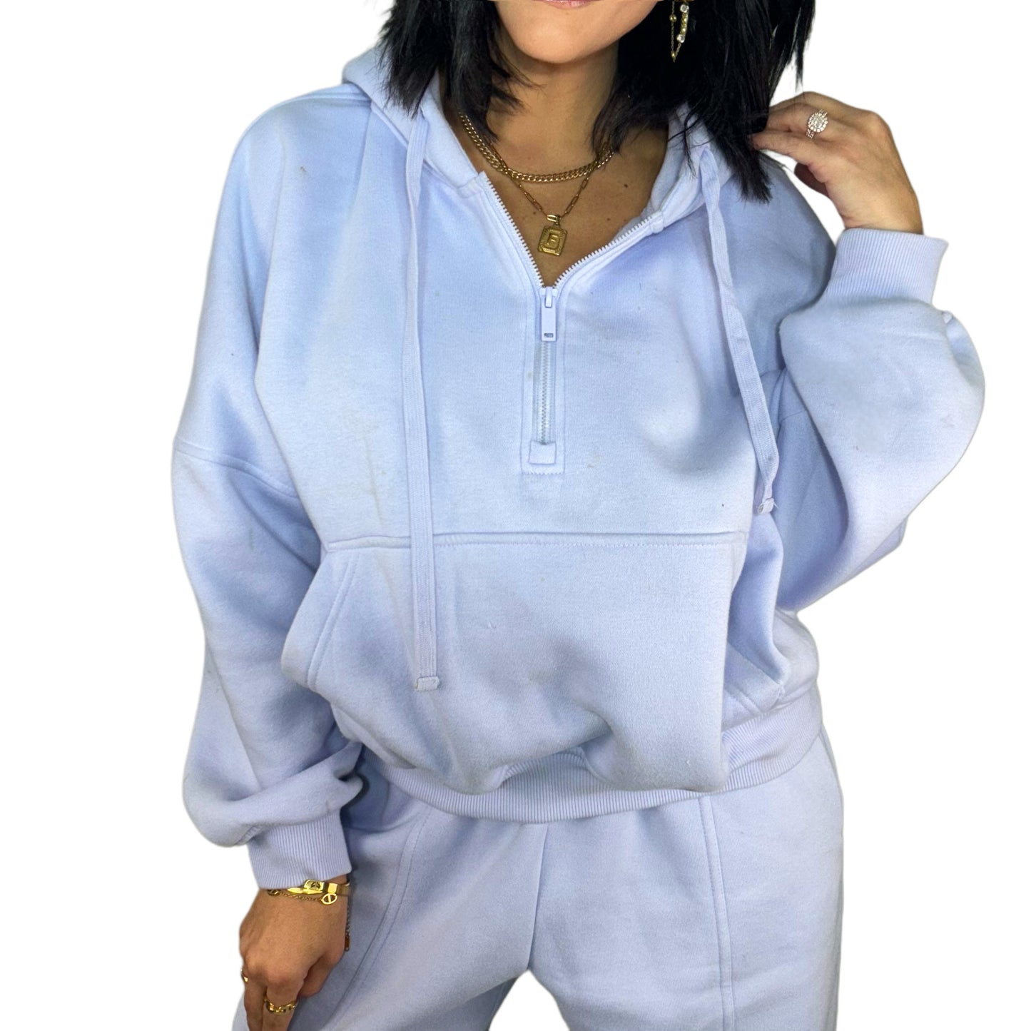 Woman wearing a light blue hoodie and pants set on a white background