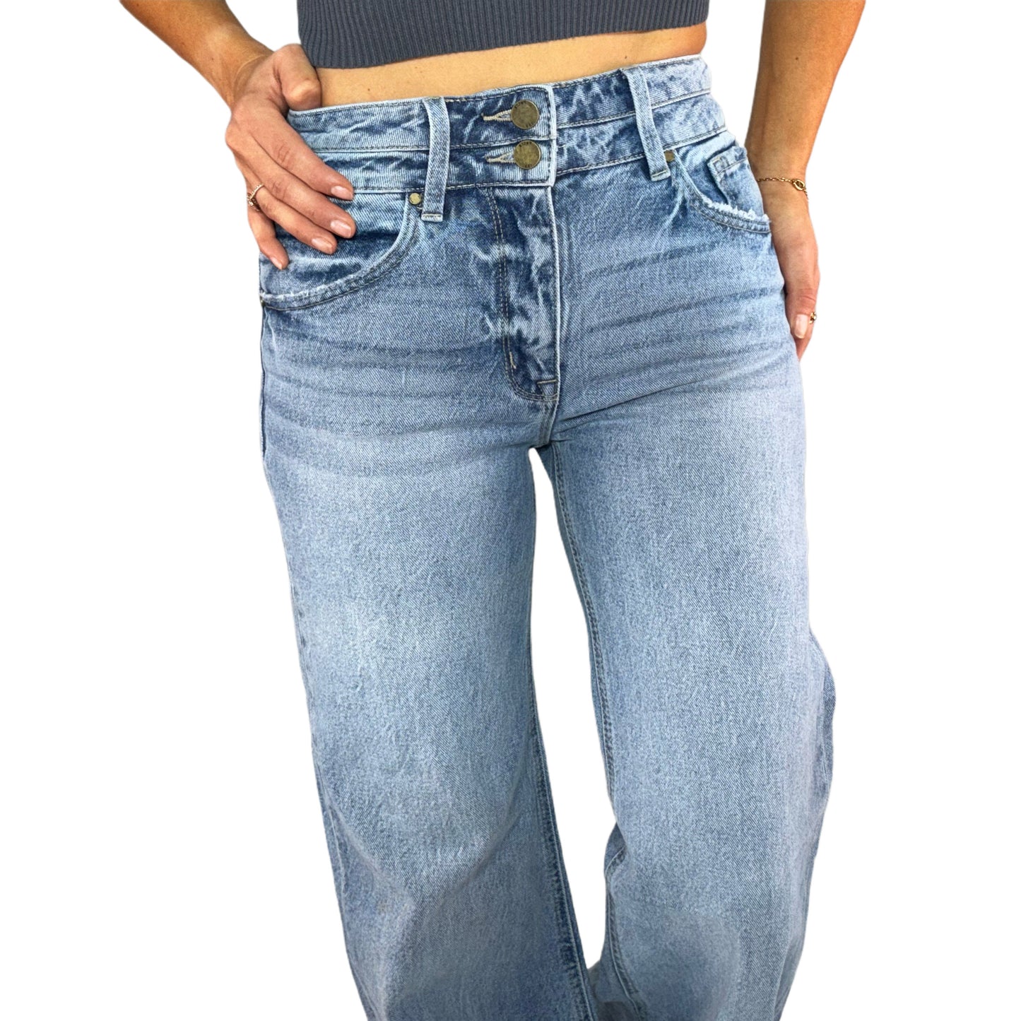 Close up of a woman wearing light denim jeans on a white background