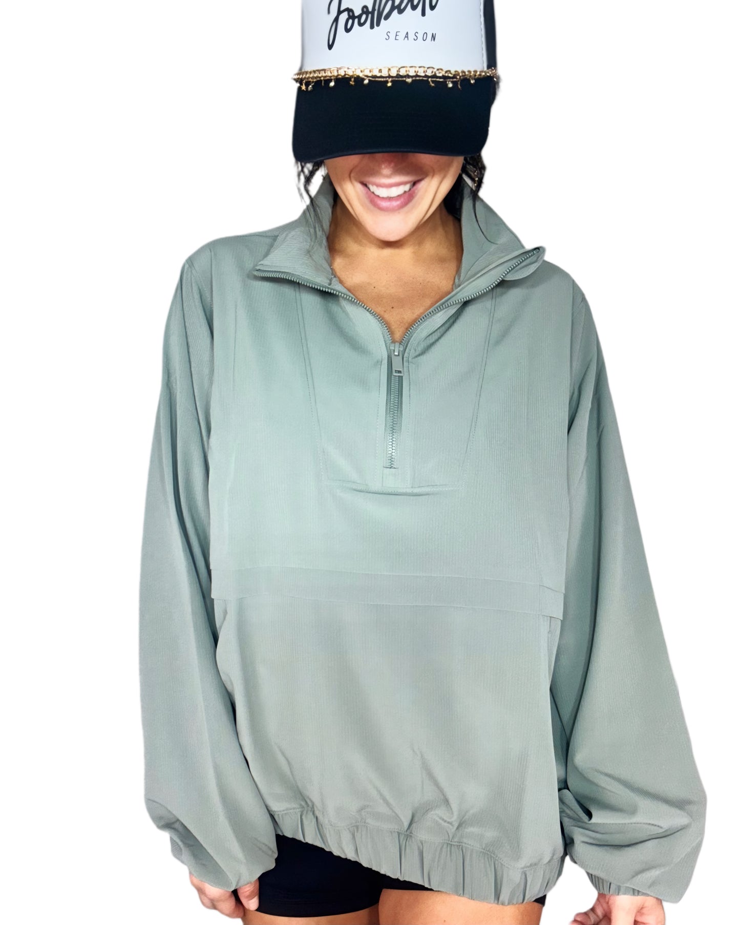 Woman wearing a light green pullover with a white cap on a white background