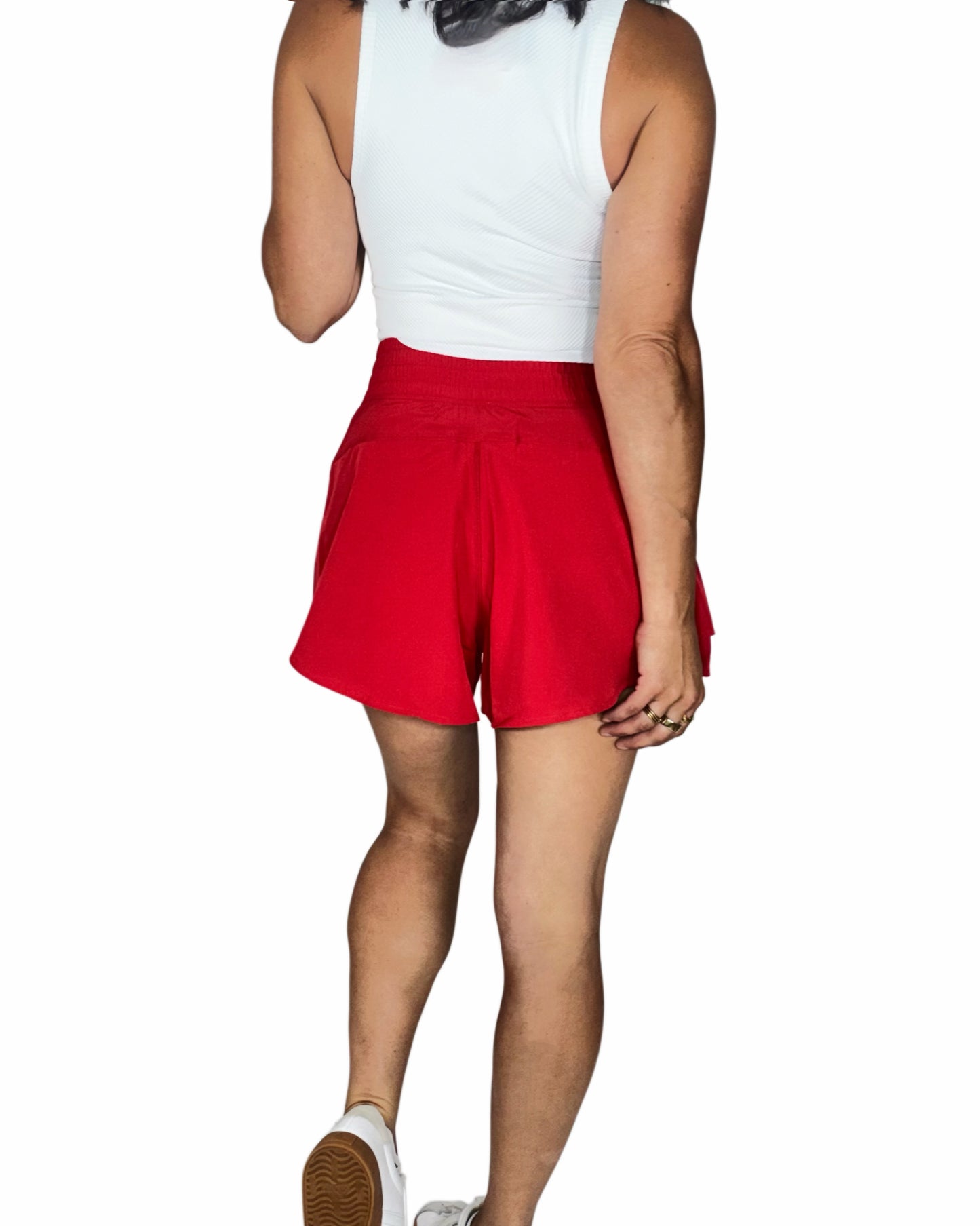 Person wearing red shorts and a white top on a white background