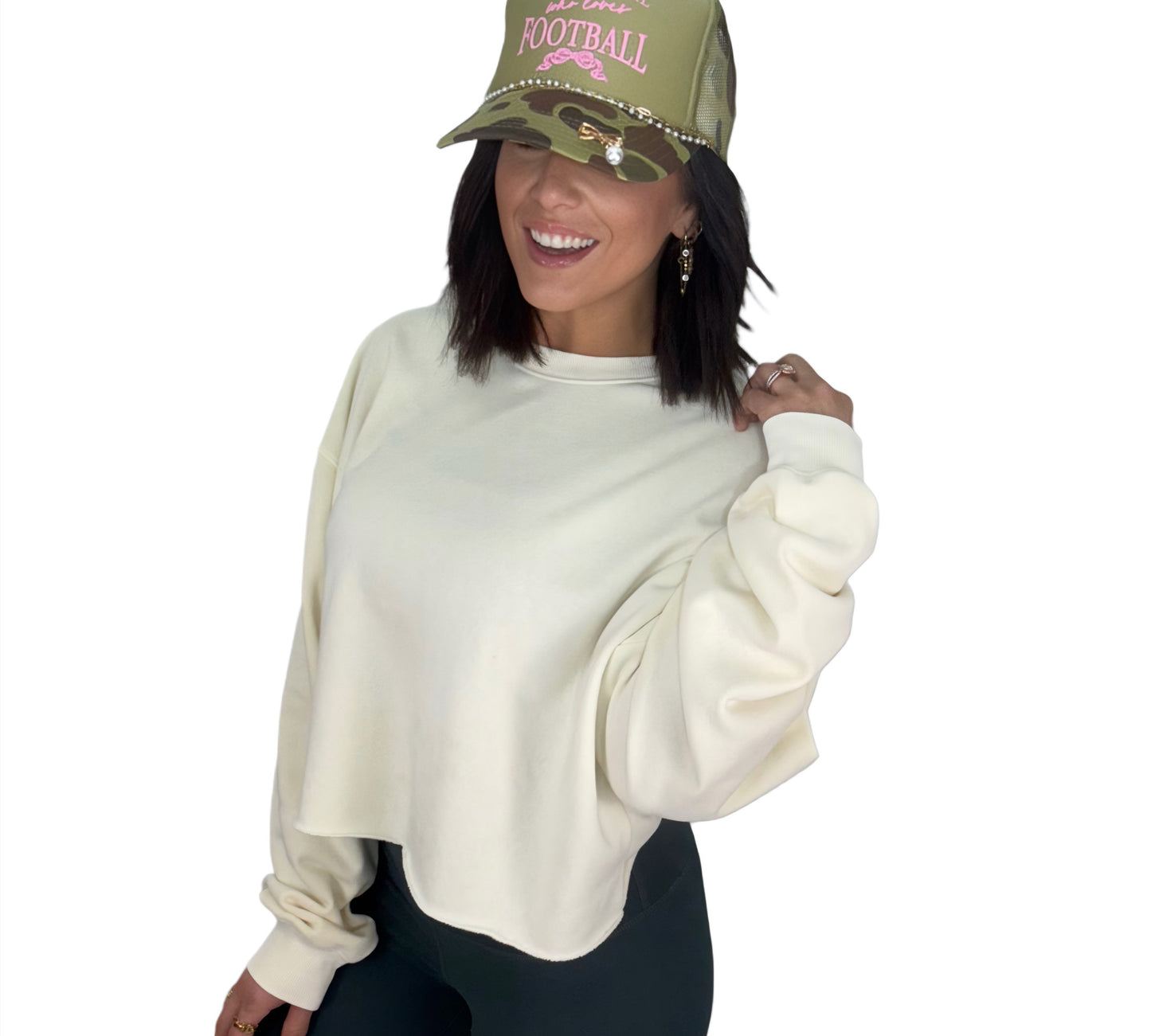 Woman wearing a cream sweatshirt and green cap with text on a white background