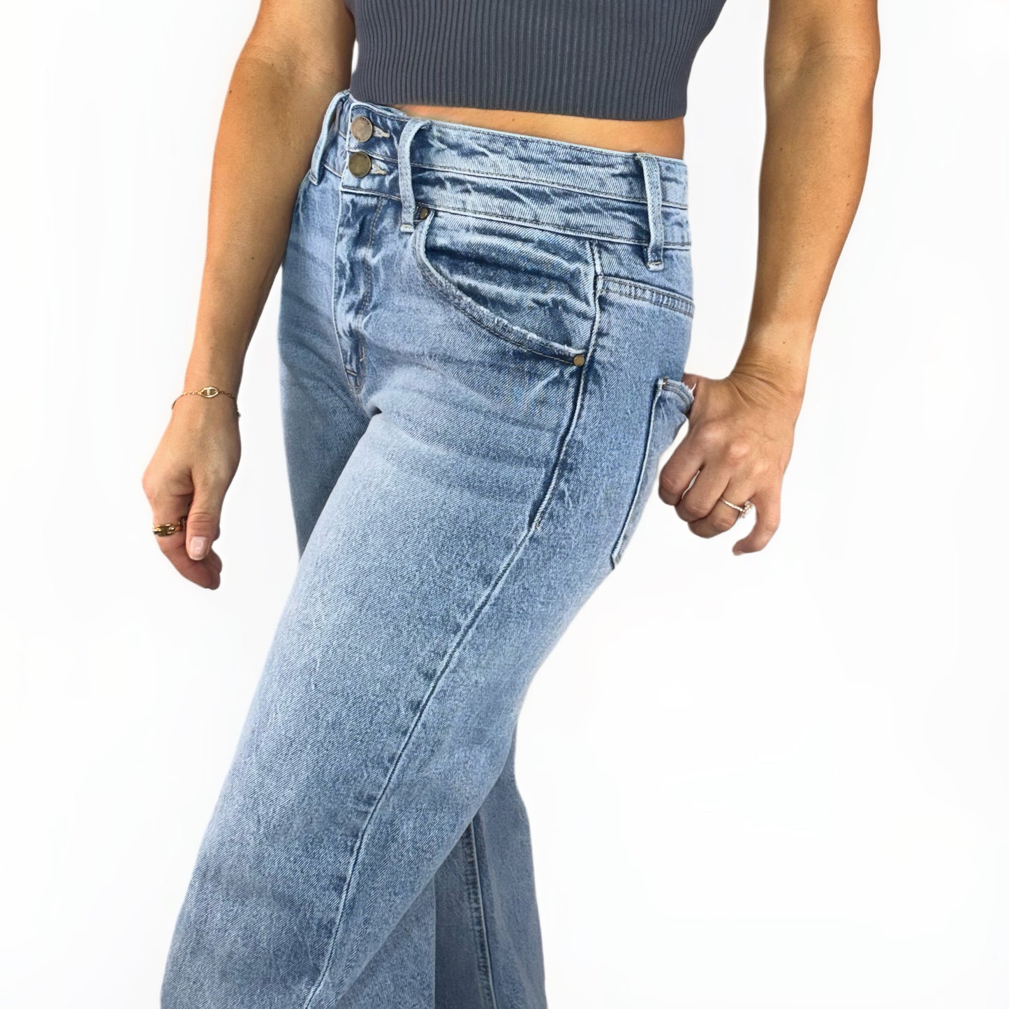 Side profile of a woman wearing light denim jeans on a white background