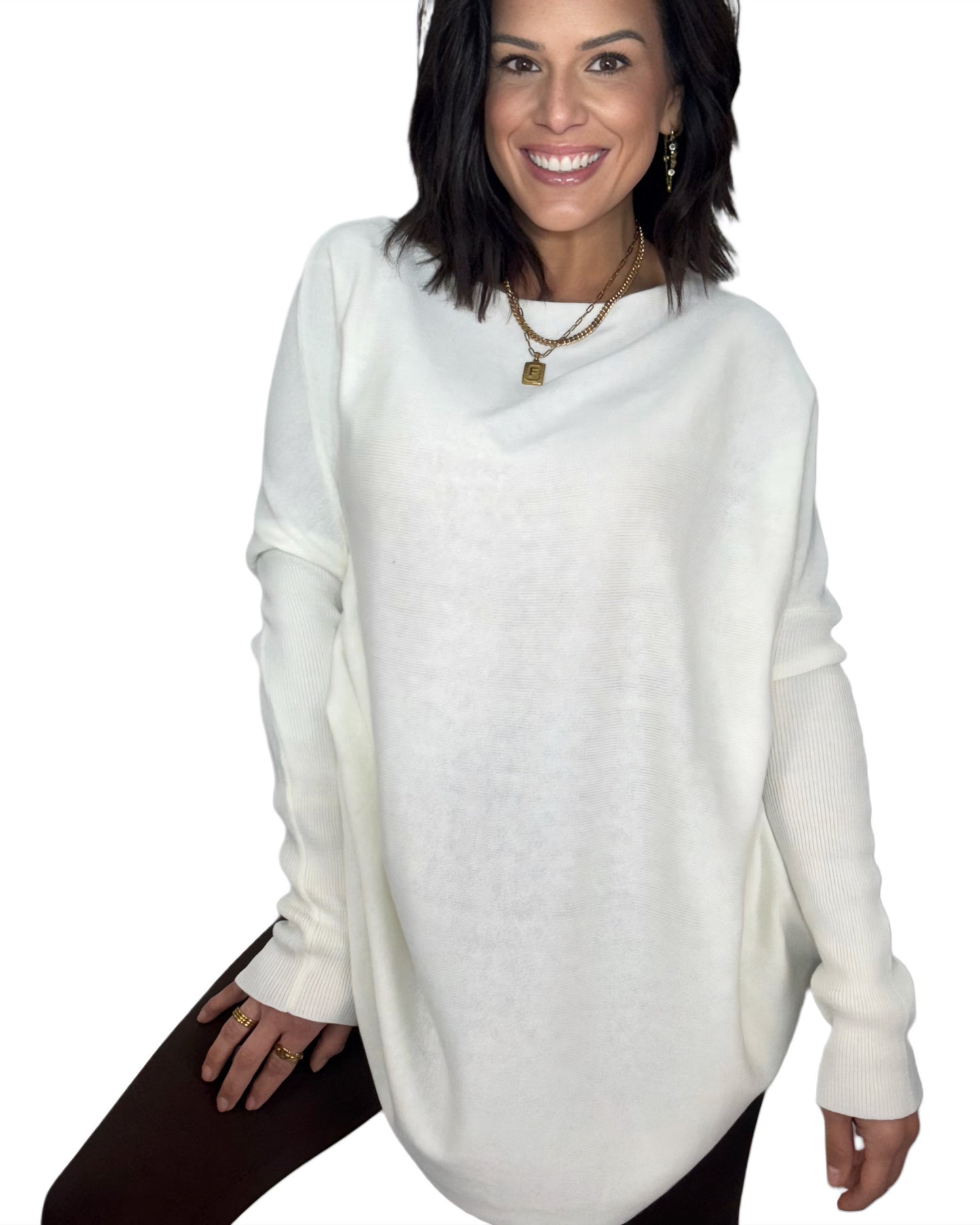 Woman wearing a white tunic top with brown leggings on a white background