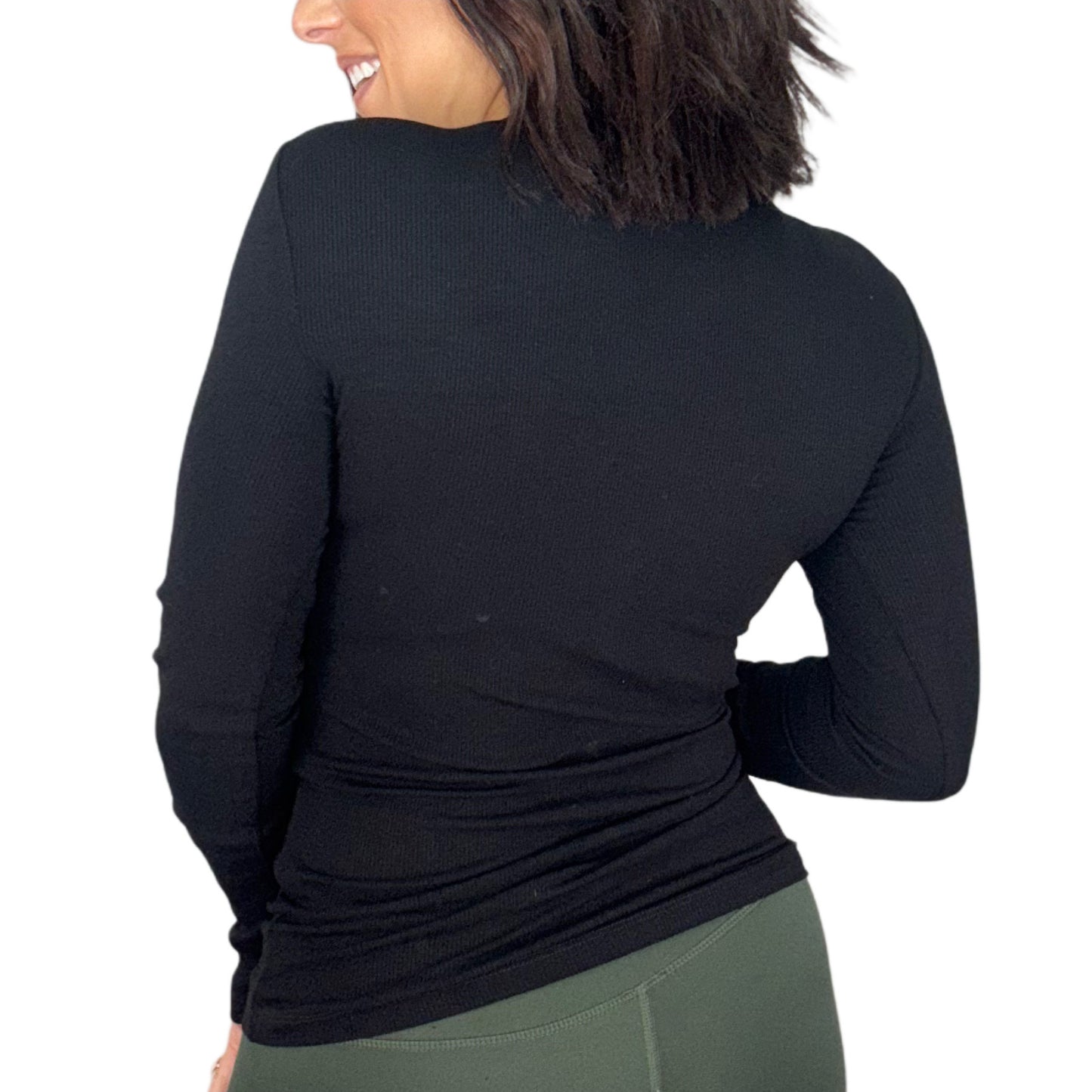 The back of a woman wearing a black ribbed long-sleeve shirt on a white background