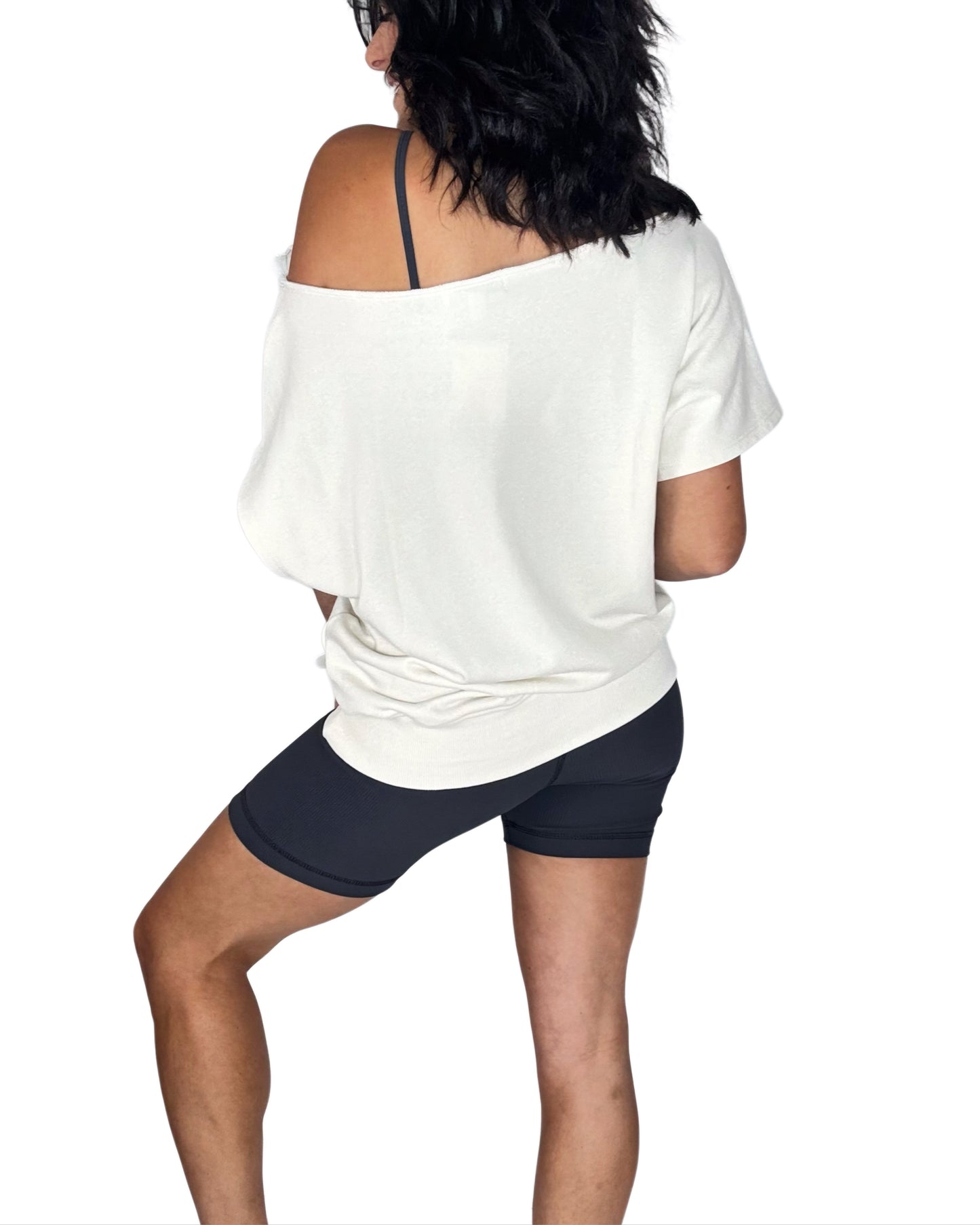 Person wearing a white off-shoulder top and black shorts on a white background