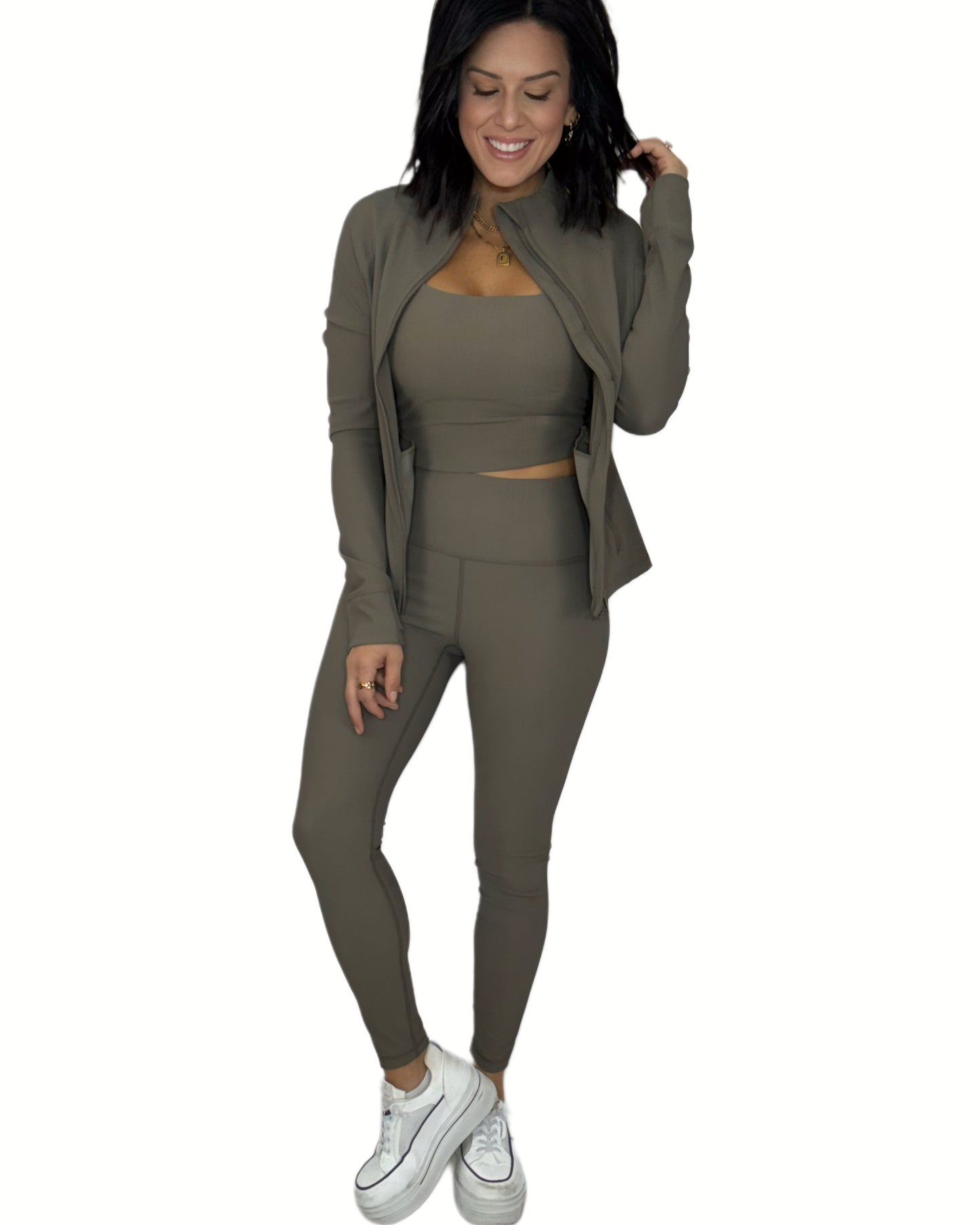 Woman wearing a ribbed green active set on a white background