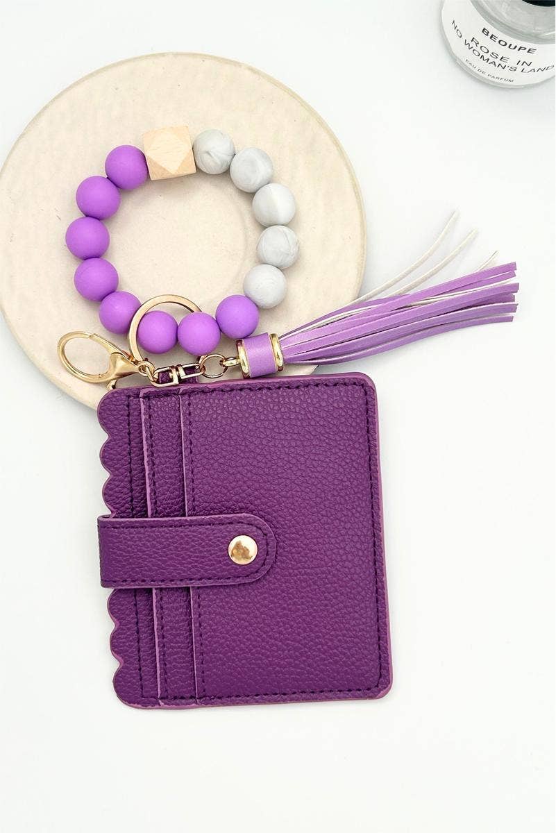 Purple wallet with keychain and tassel on a white background