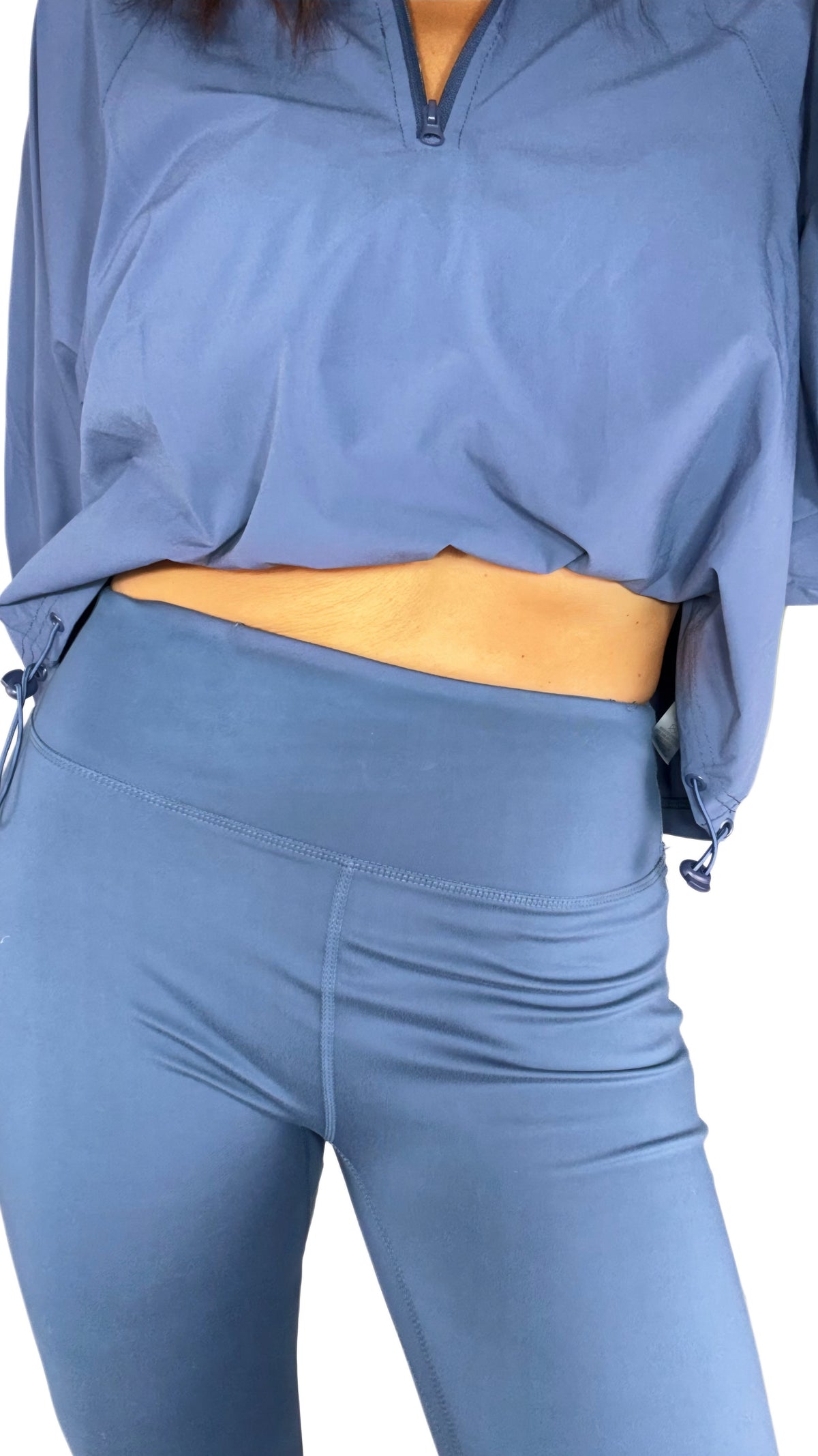 Close up of a woman wearing blue active leggings with a matching op on a white background 