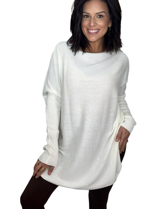 Woman wearing a white tunic top and brown athletic leggings on white background