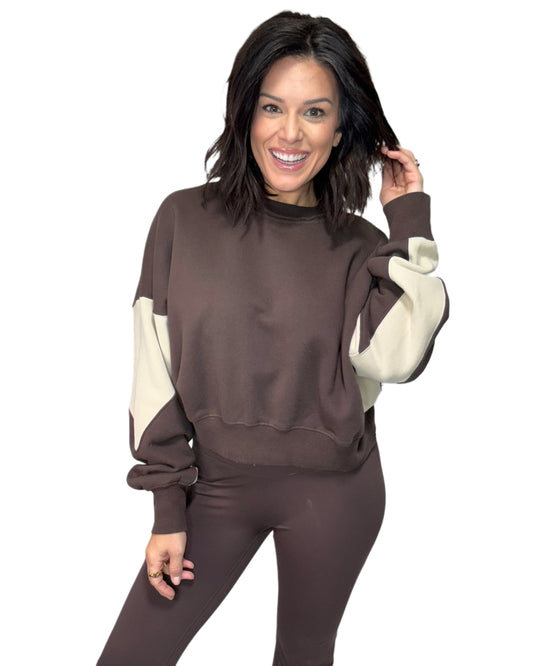 Woman wearing a brown and cream outfit on a white background
