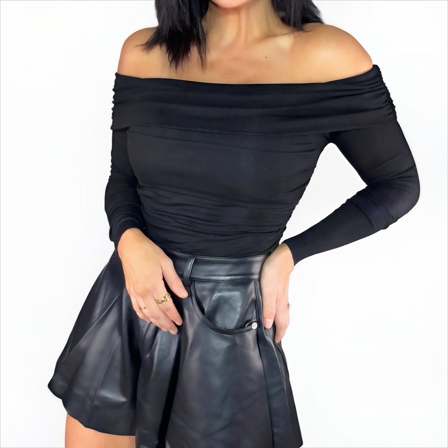 Black off-shoulder bodysuit and leather shorts on a white background