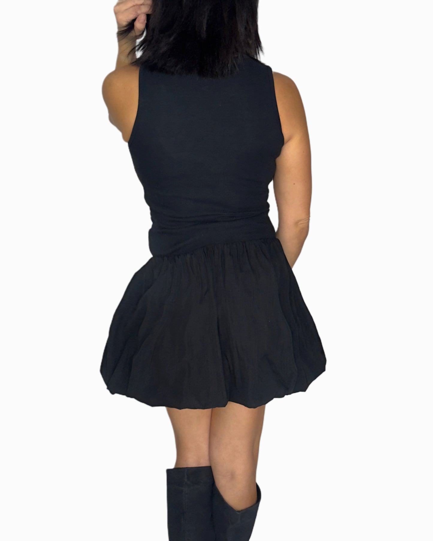 Back profile of a woman wearing a sleeveless dress worn by a person on a white background