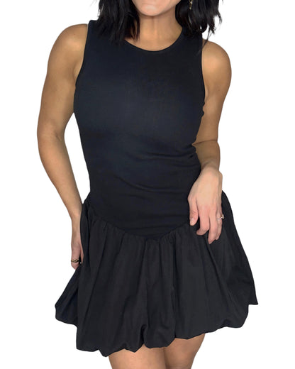 Close up of a woman wearing a black sleeveless dress worn by a person on a white background