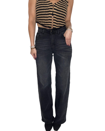 Person wearing black wide-leg jeans on a white background