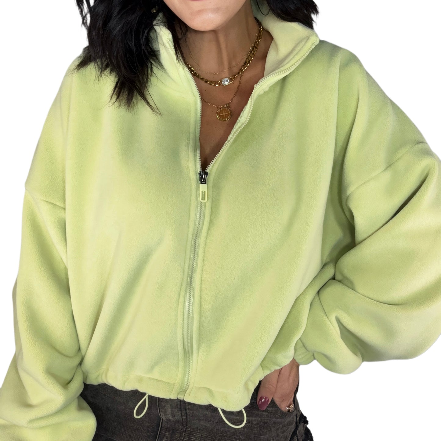 Person wearing a light green zip-up fleece on a white background