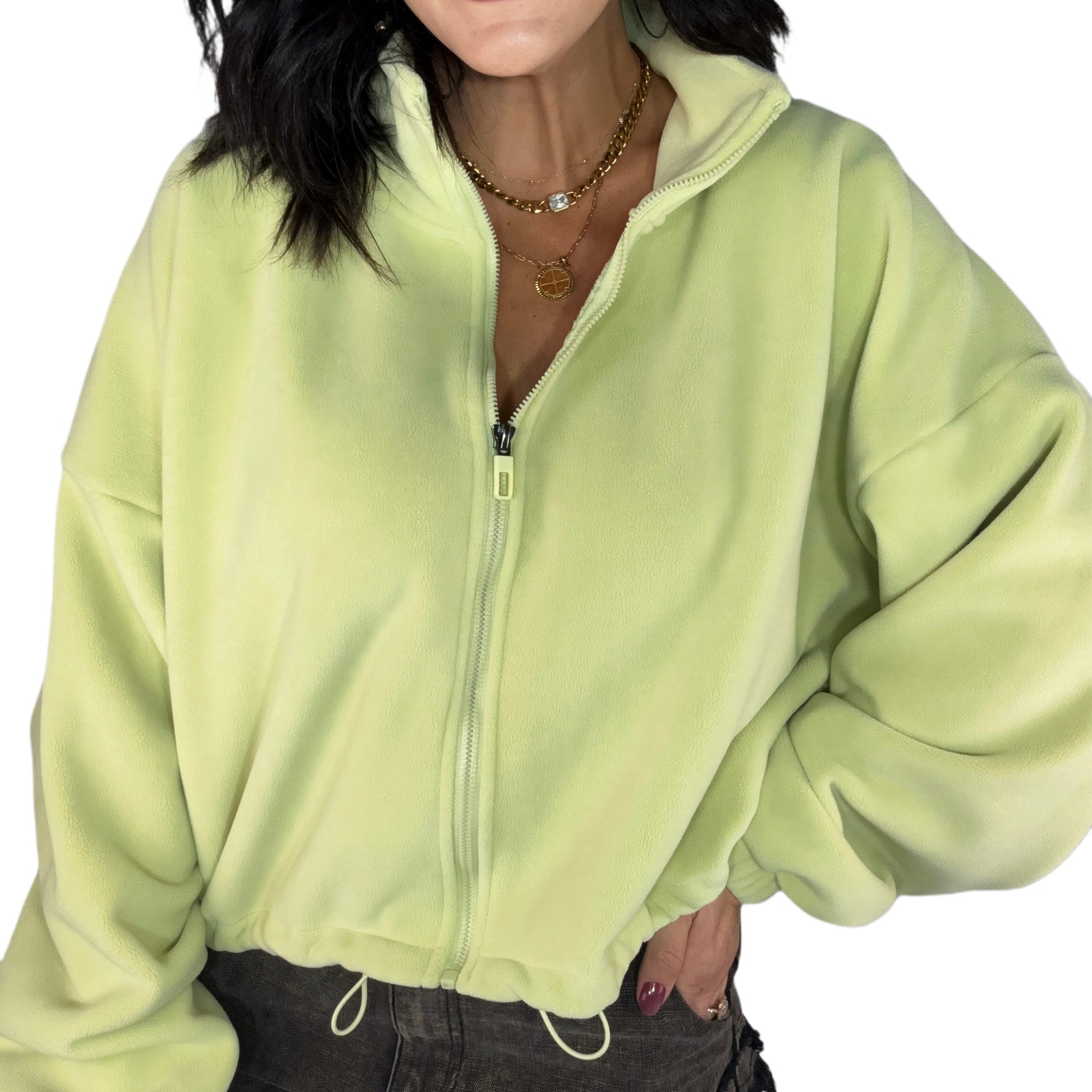 Person wearing a light green zip-up fleece on a white background