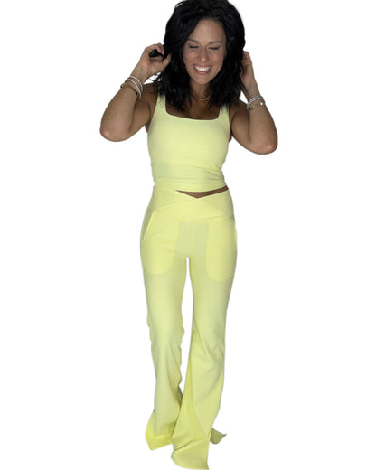 Woman wearing a ribbed yellow active pant set on a white background