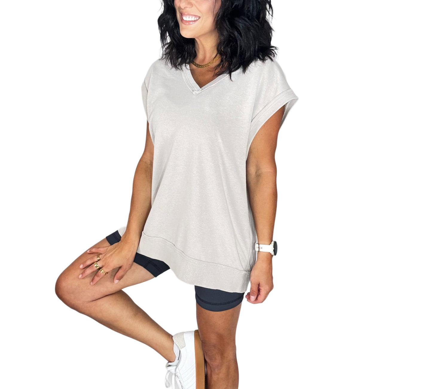 Woman wearing a light gray oversized t-shirt and black shorts on a white background