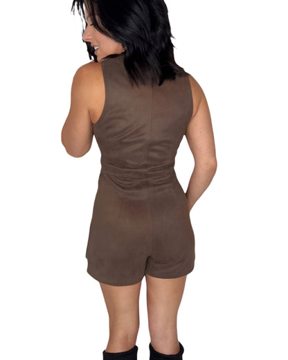 Back profile of woman wearing a brown sleeveless suede romper on a white background