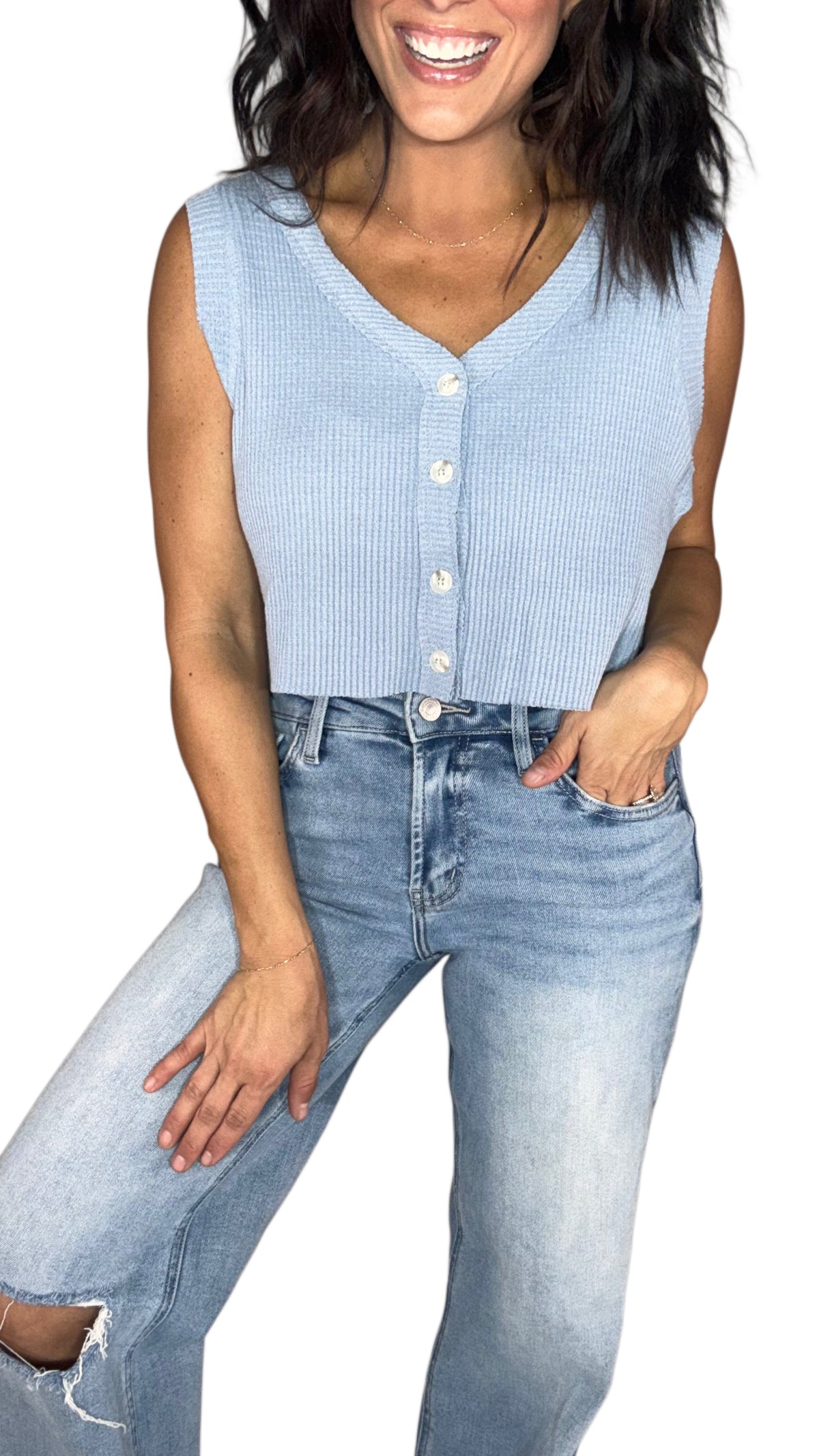 Close up of a woman wearing a light blue waffle sleeveless top with medium wash jeans, on a white background