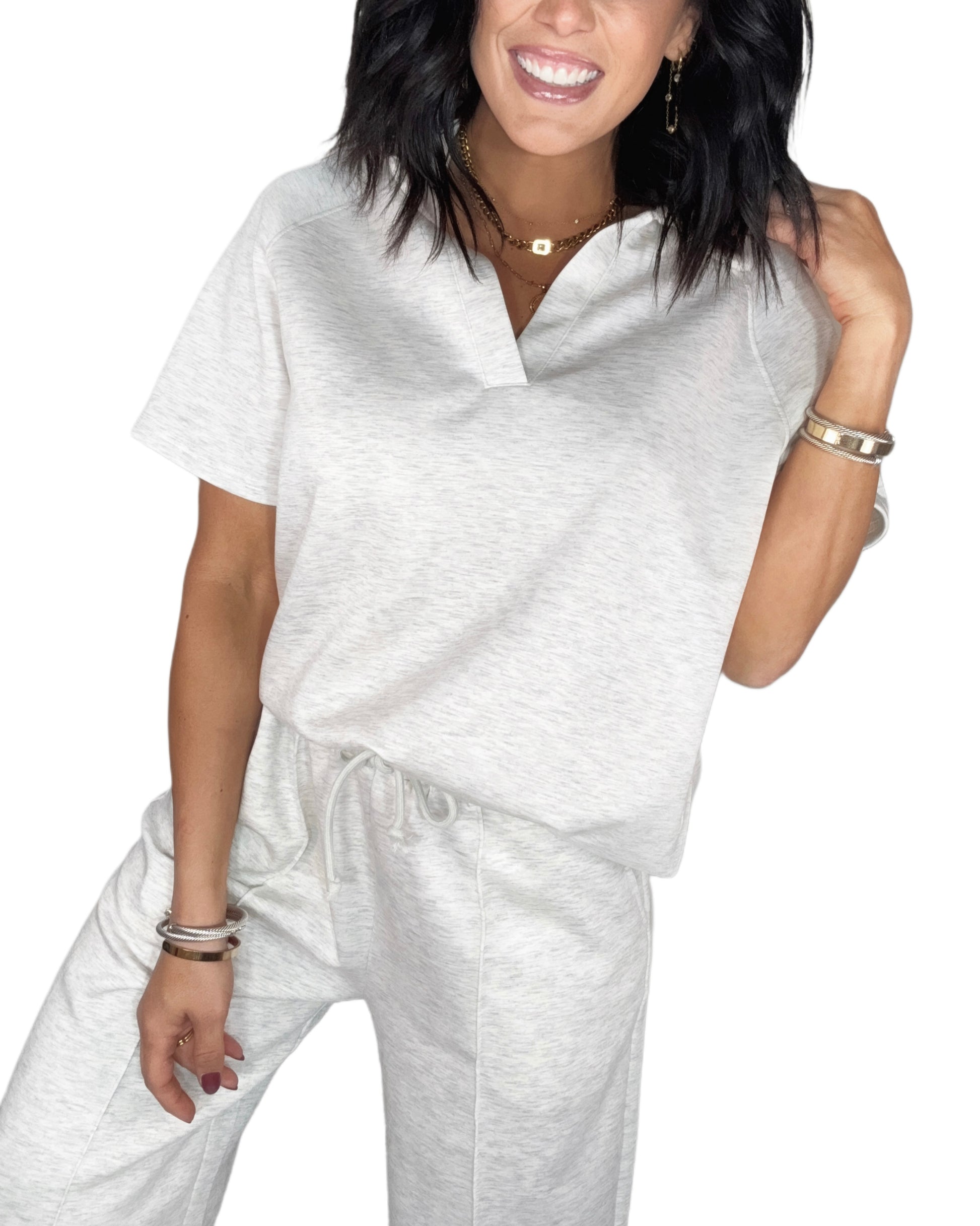 Close up of a woman wearing a light gray  lounge outfit with a white background