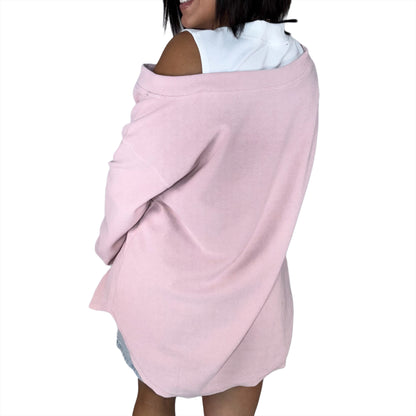 Woman wearing a light drop shoulder top, modeling the back  on a white background