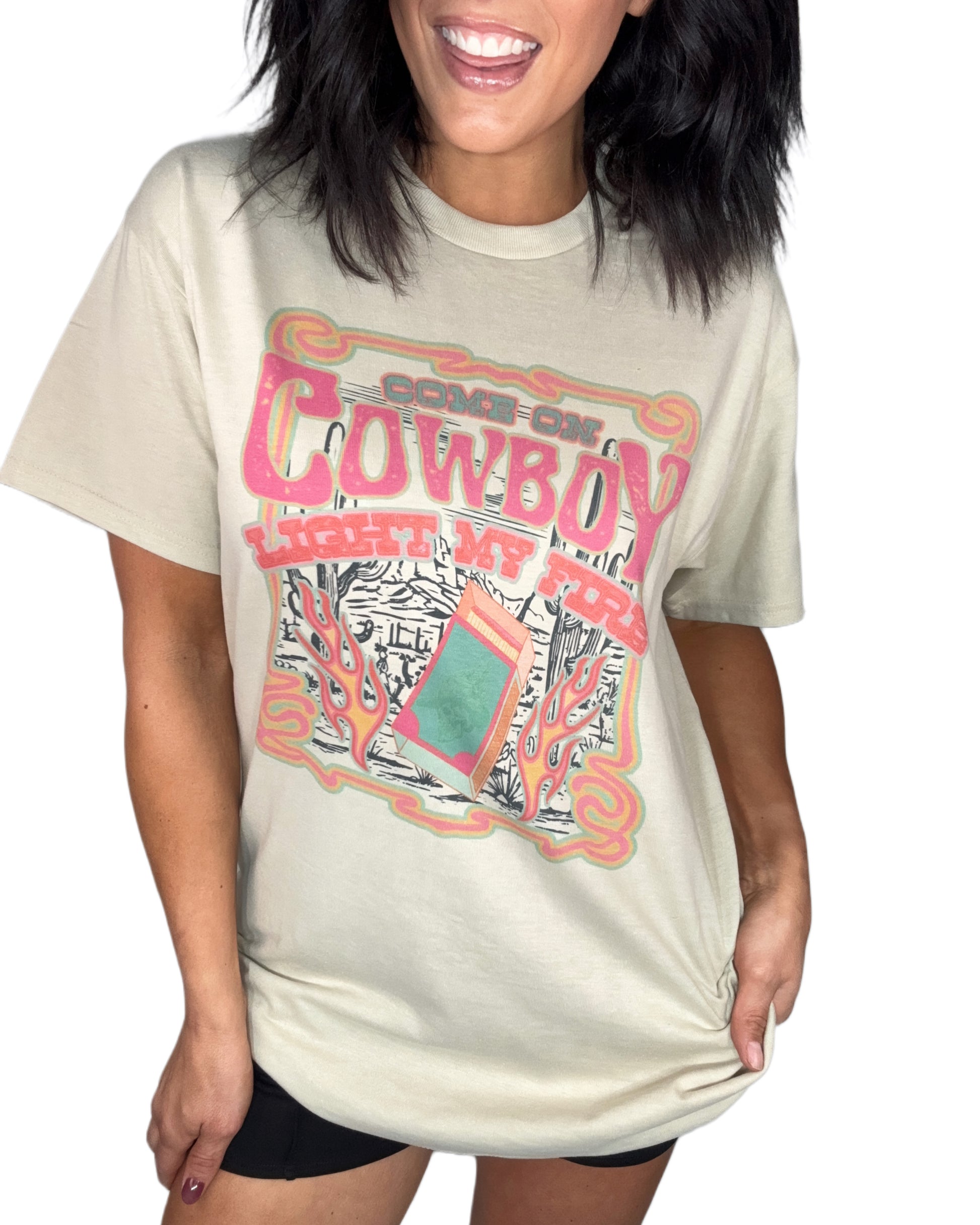 Woman wearing a sand t-shirt with colorful graphic design on a white background