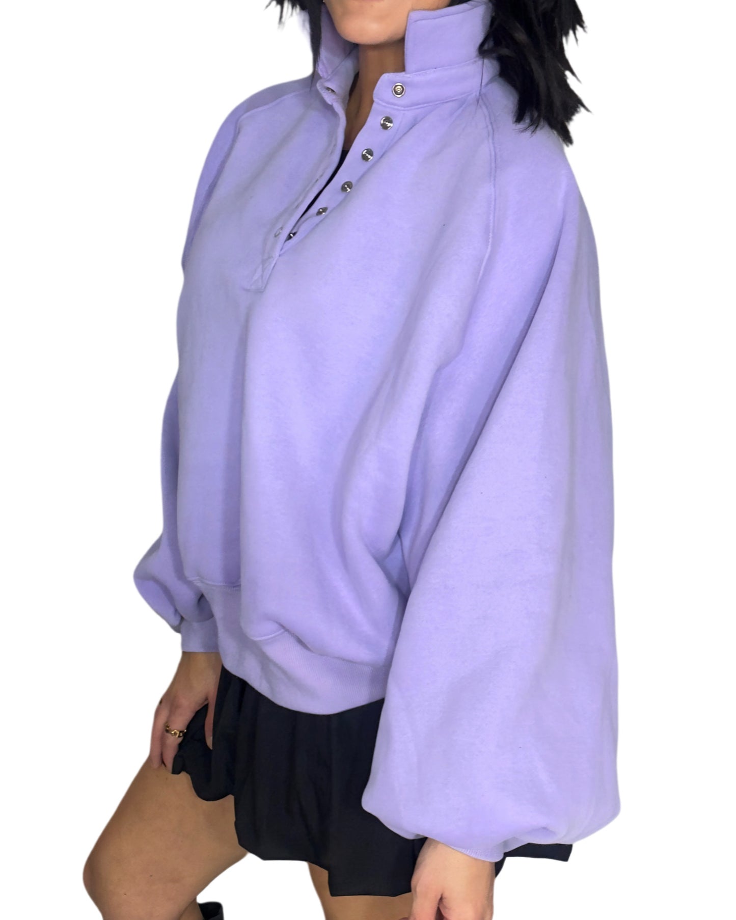 Side profile of a woman wearing a light purple oversized sweater on a white background