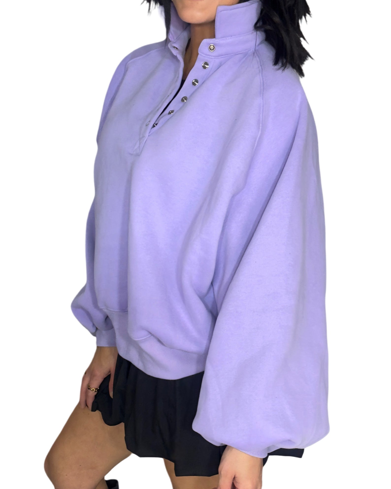 Side profile of a woman wearing a light purple oversized sweater on a white background