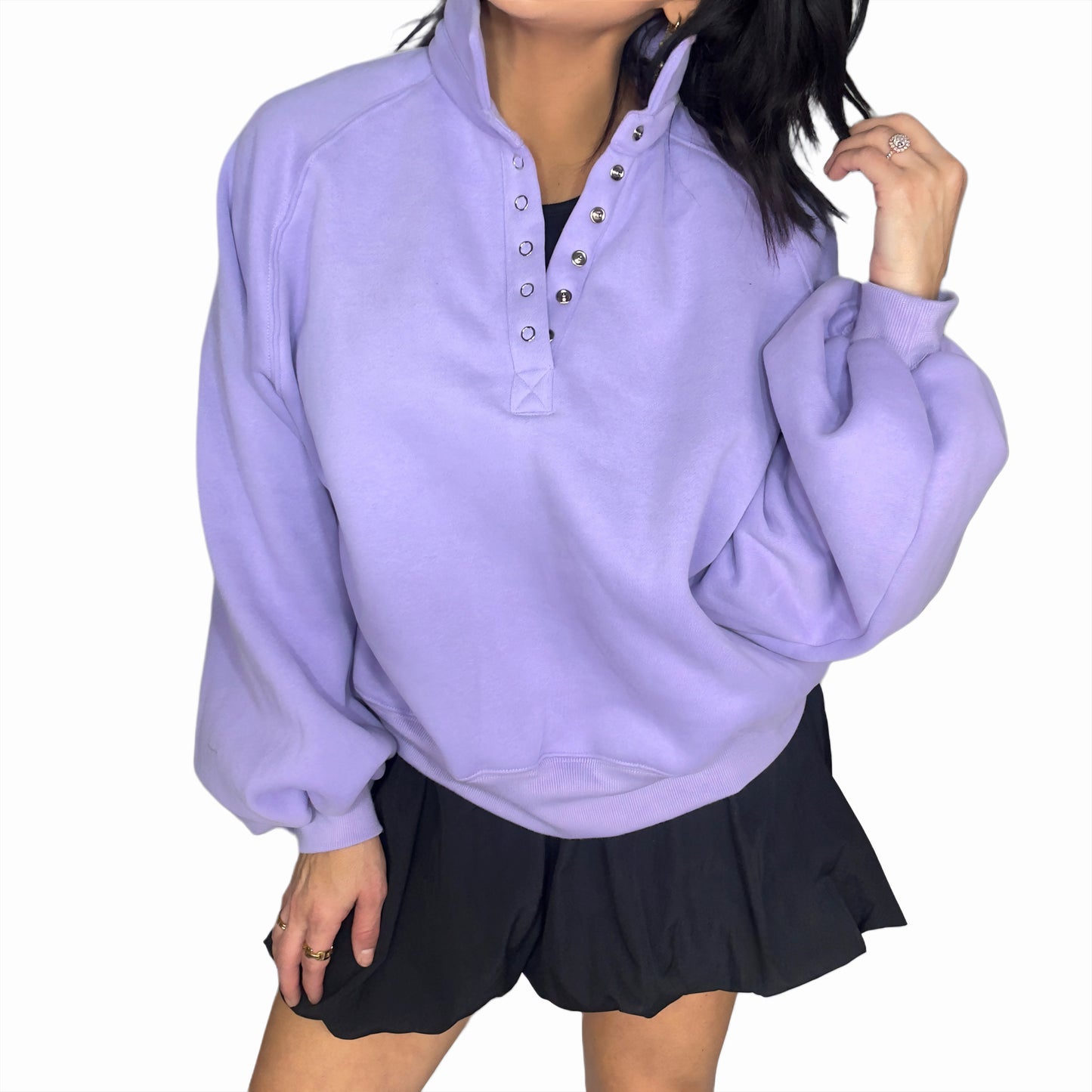 Woman wearing a light purple pullover with a high collar and black dress on a white background