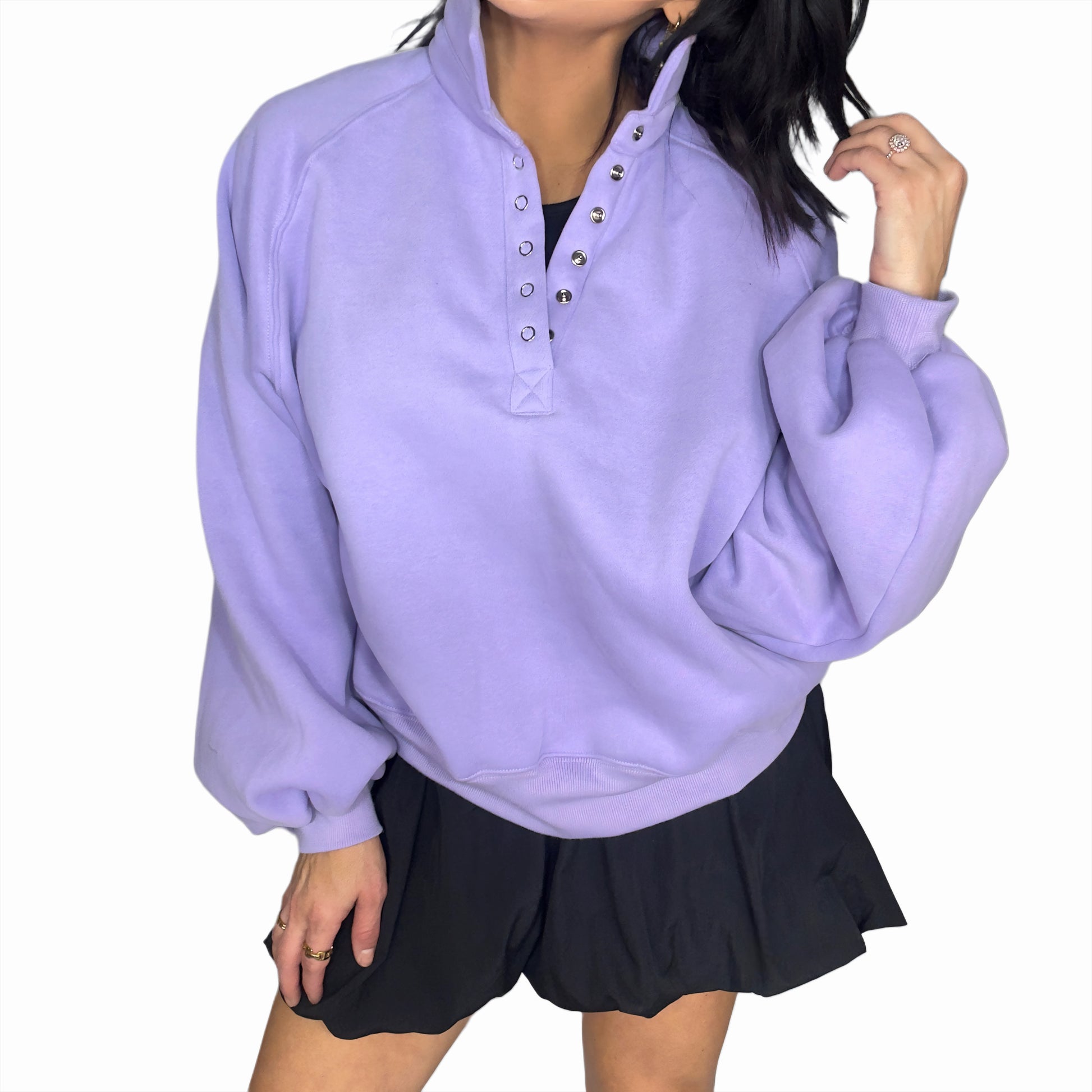 Woman wearing a light purple pullover with a high collar and black dress on a white background