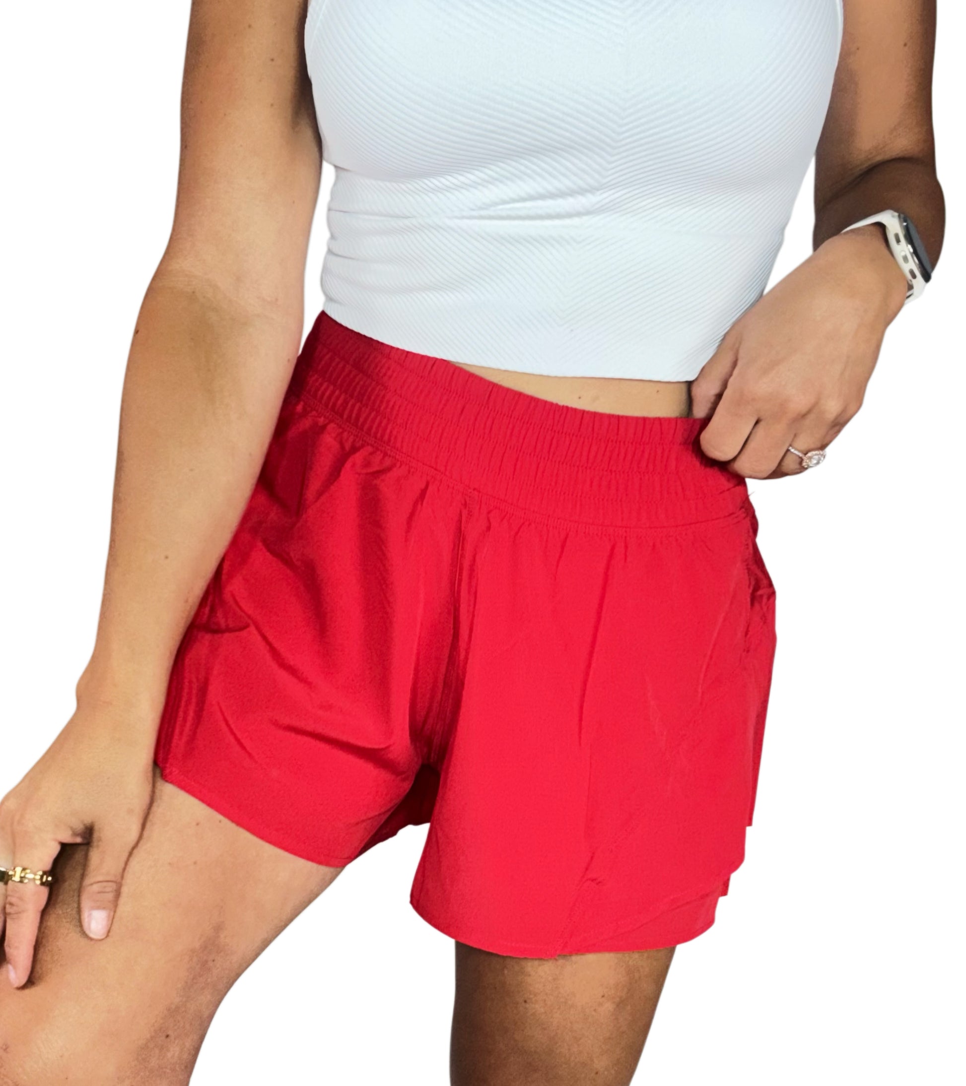 Person wearing red shorts and a white top on a white background