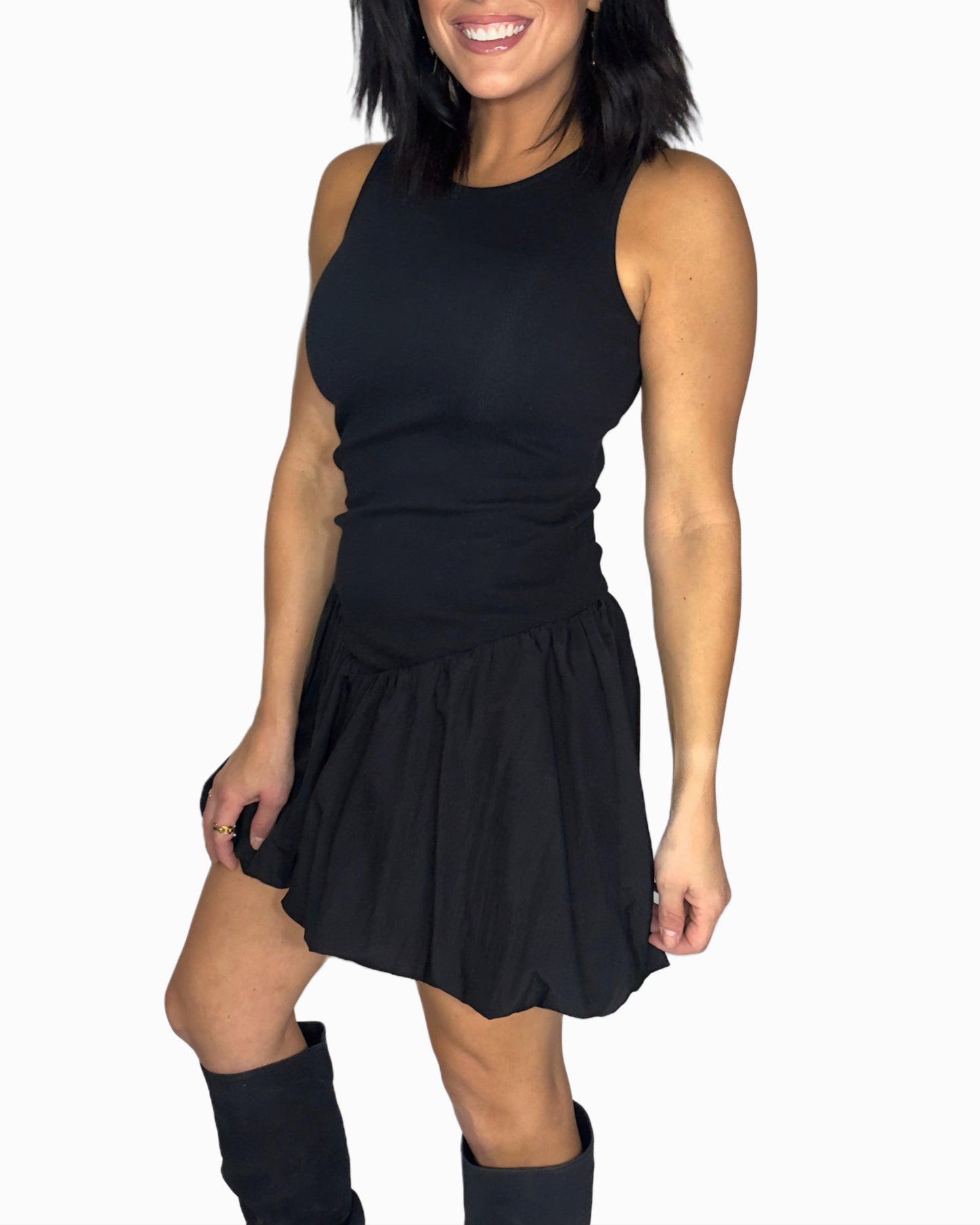Side profile of a woman wearing a black sleeveless top and black skirt on a white background