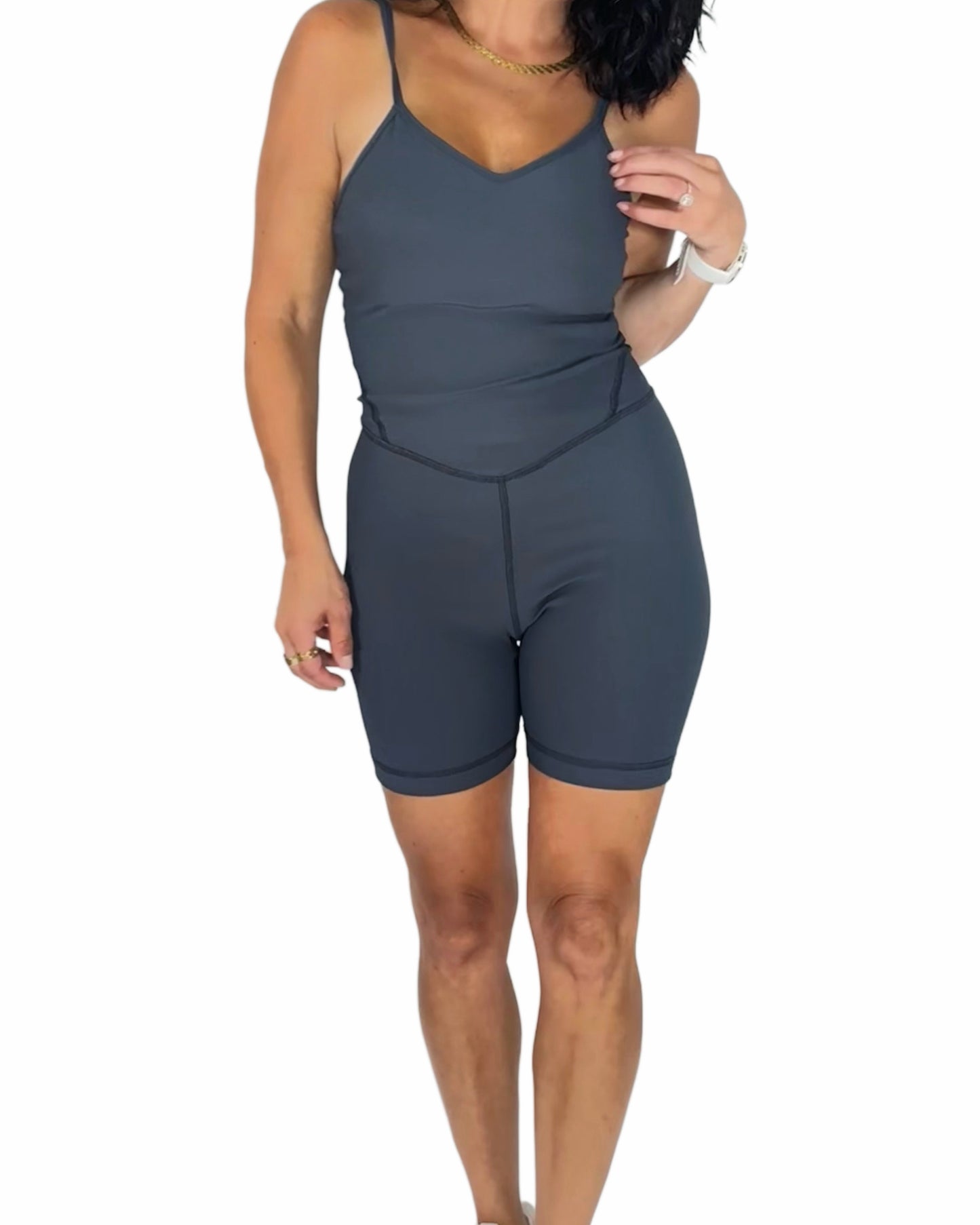 Woman wearing a gray active ribbed romper on a white background