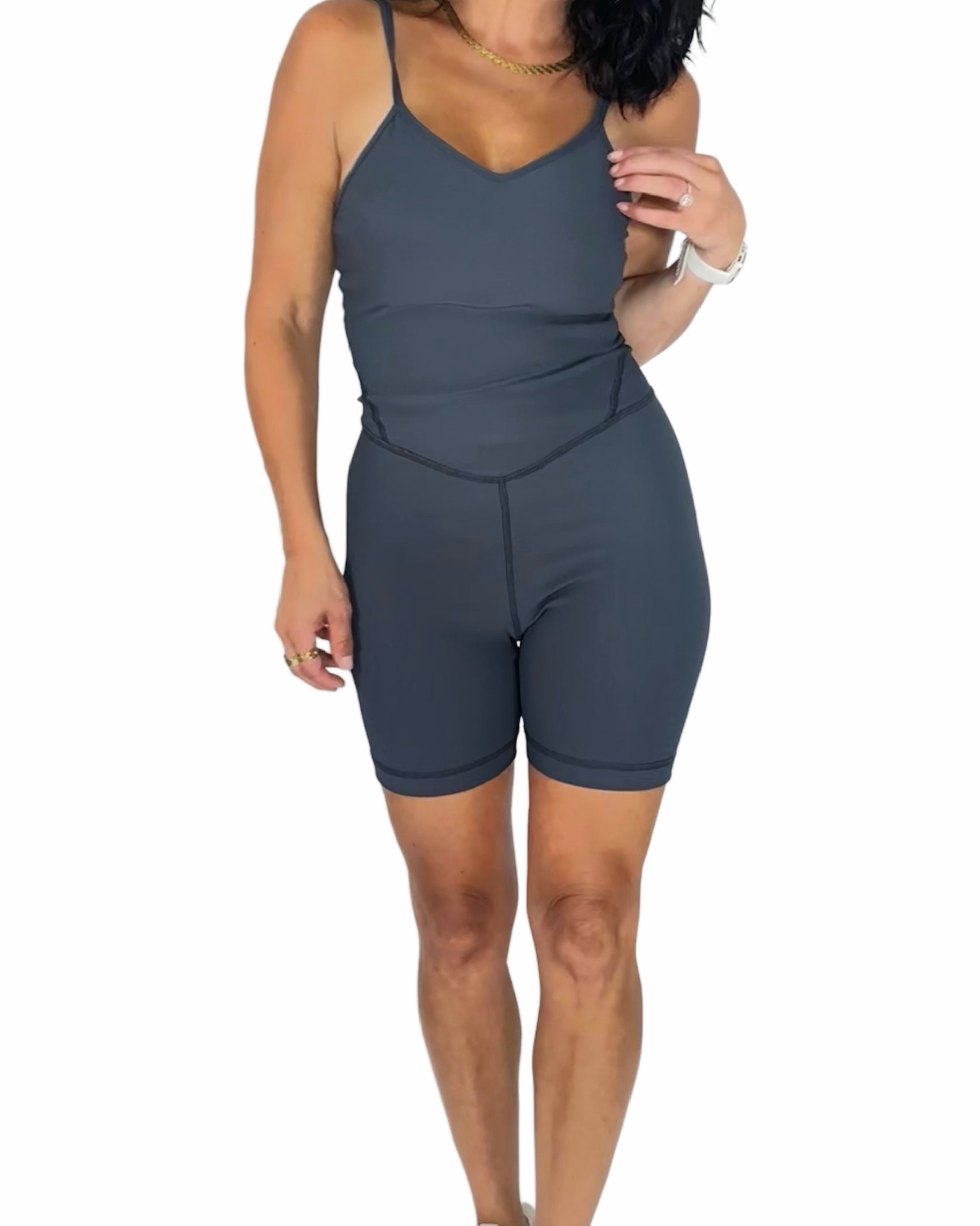 Woman wearing a gray active ribbed romper on a white background