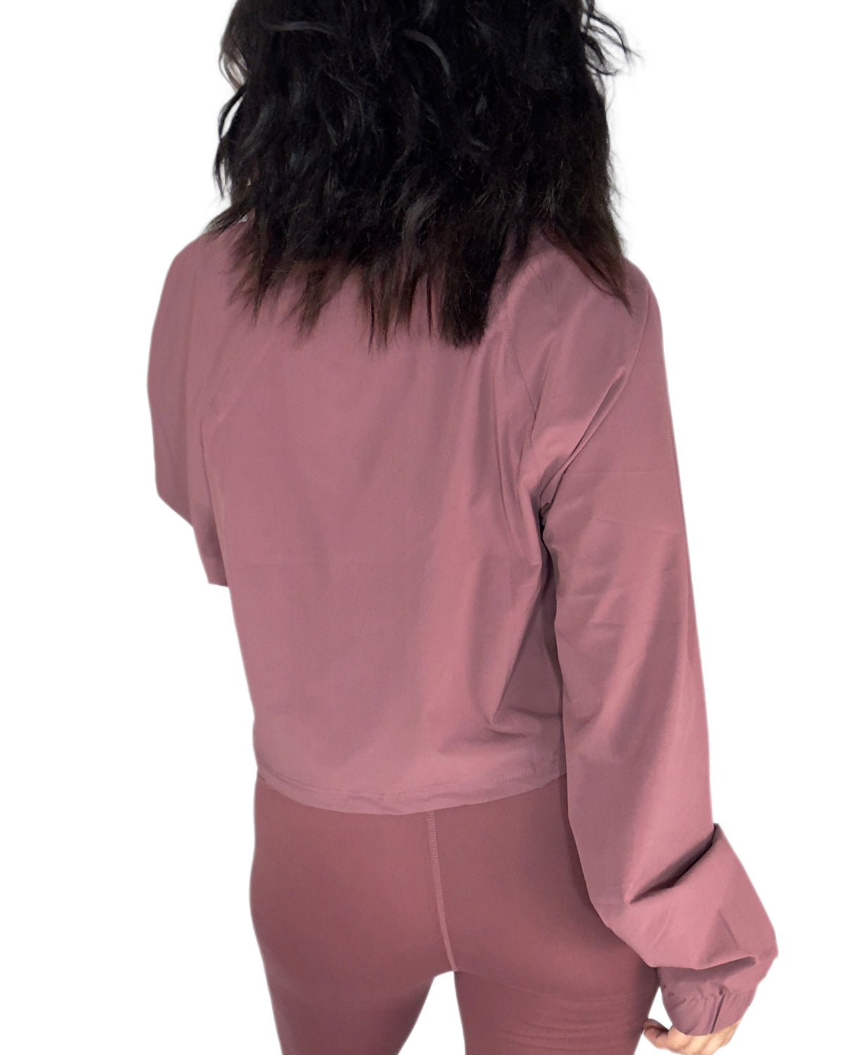 Back profile of a woman wearing an active half zip with matching leggings in rosewood mauve on a white background 