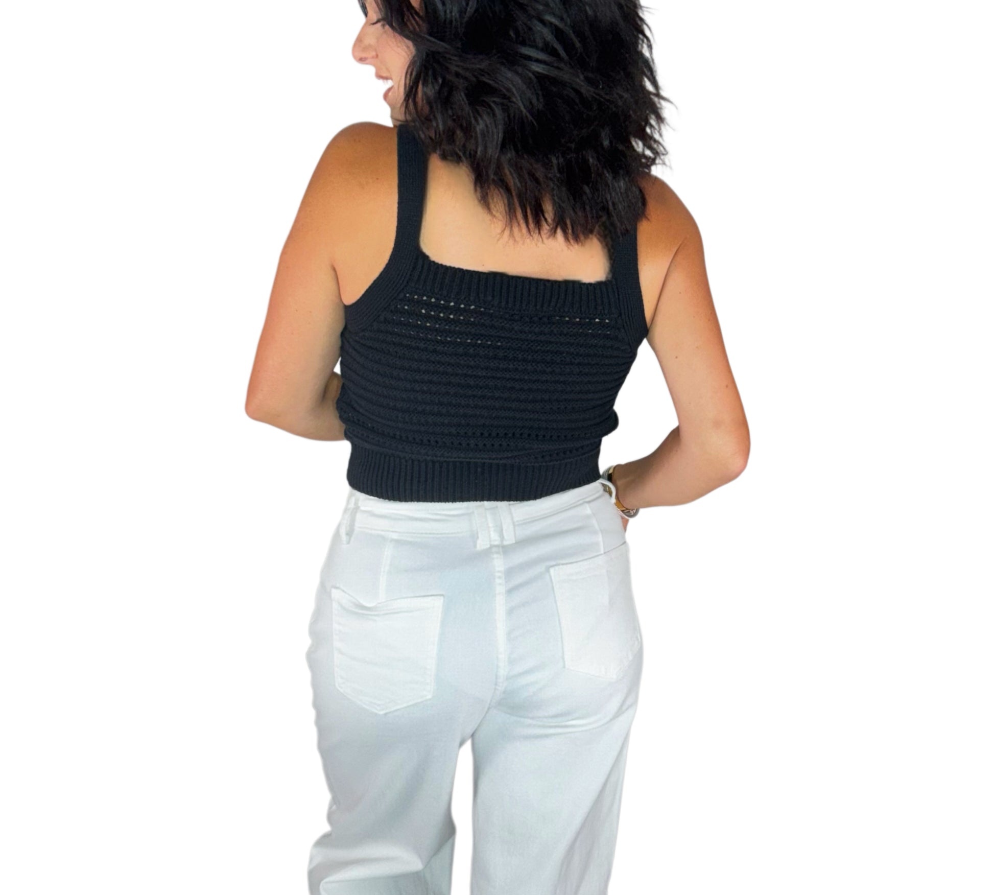 Bac profile of a woman wearing a knit black top with white bottoms on a white background