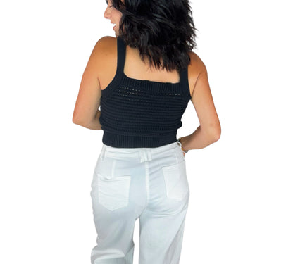Bac profile of a woman wearing a knit black top with white bottoms on a white background