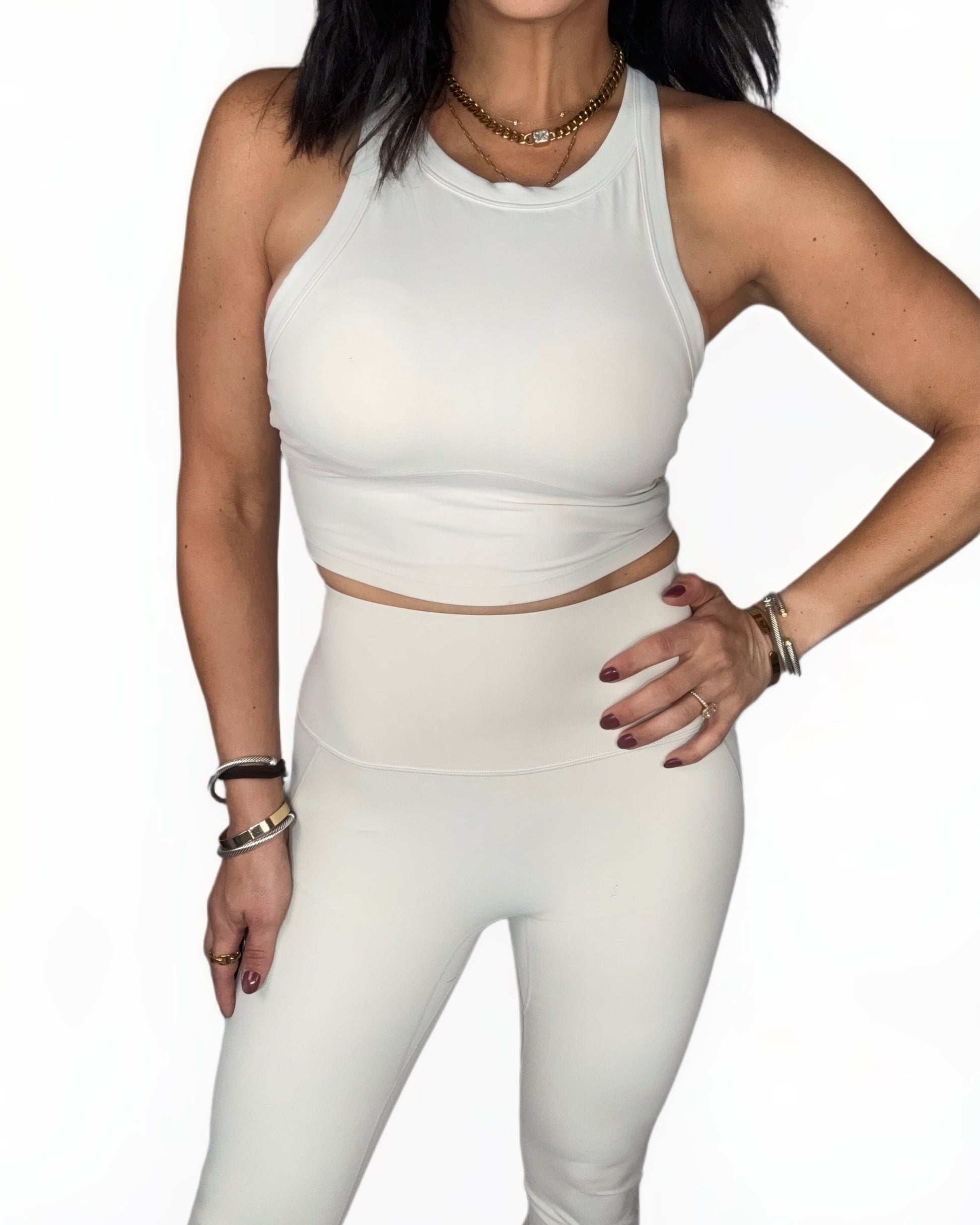 Woman wearing a off white athletic outfit on a white background