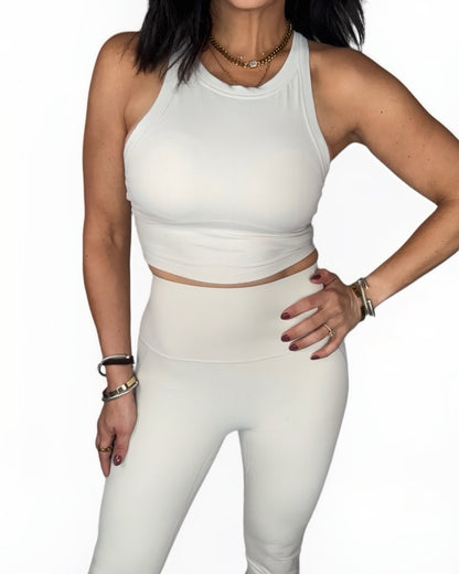 Woman wearing a off white athletic outfit on a white background