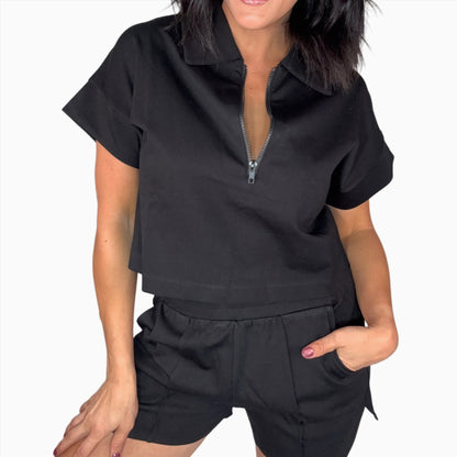 Close up of a woman wearing a black short set on a white background