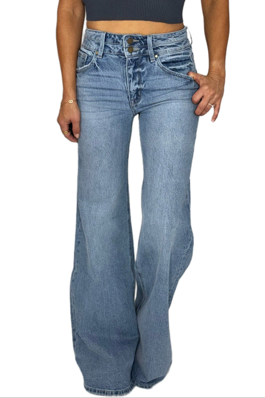 Woman wearing wide leg jeans with double top buttons on a white background
