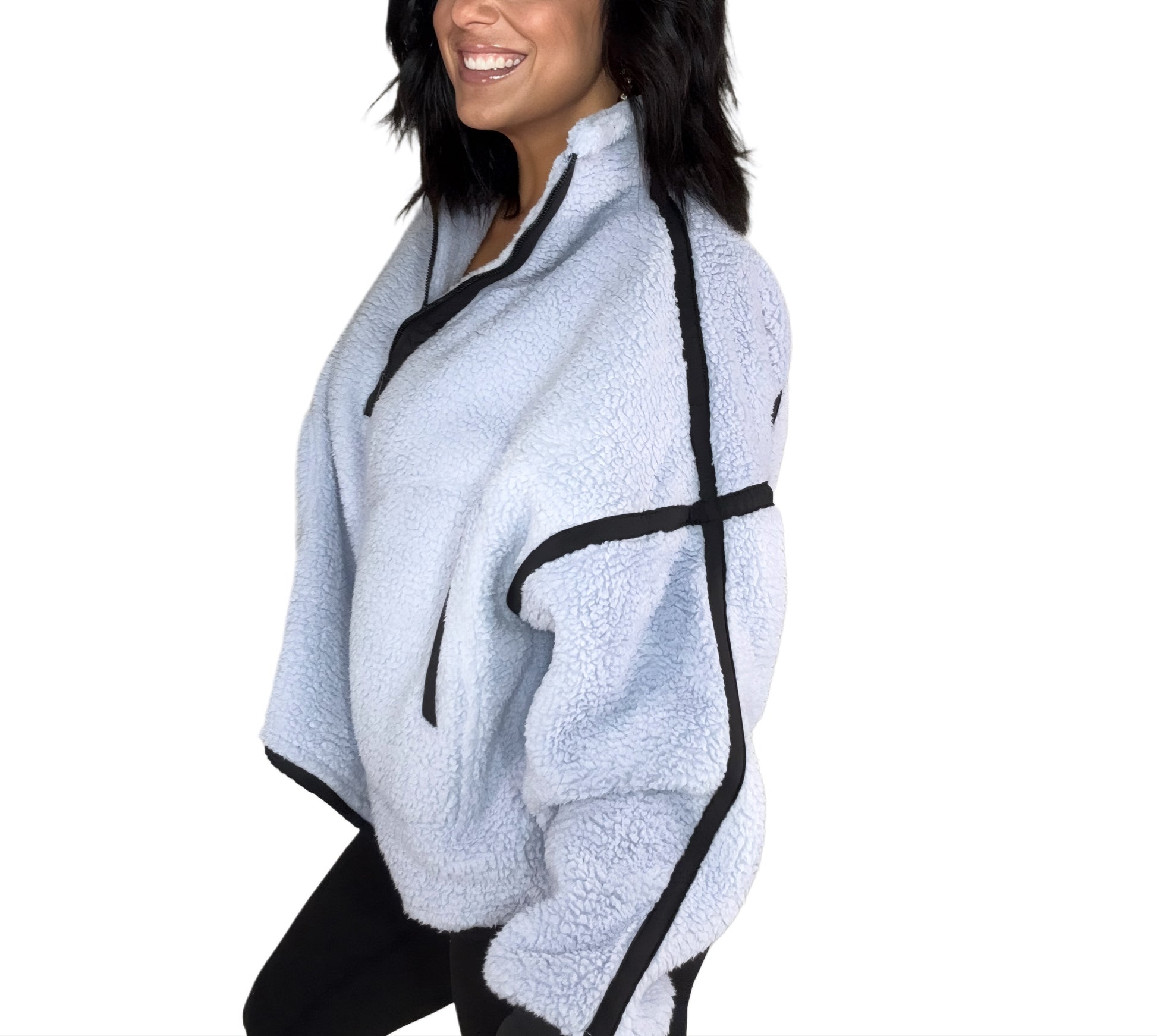 Side profile of a woman wearing a light blue fleece pull over with black trim on a white background