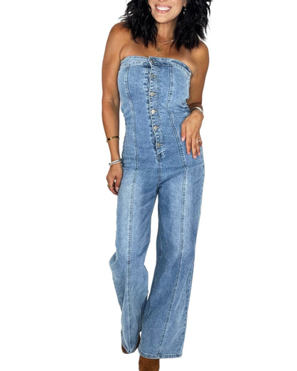 Woman wearing a jean button down jumpsuit on a white background